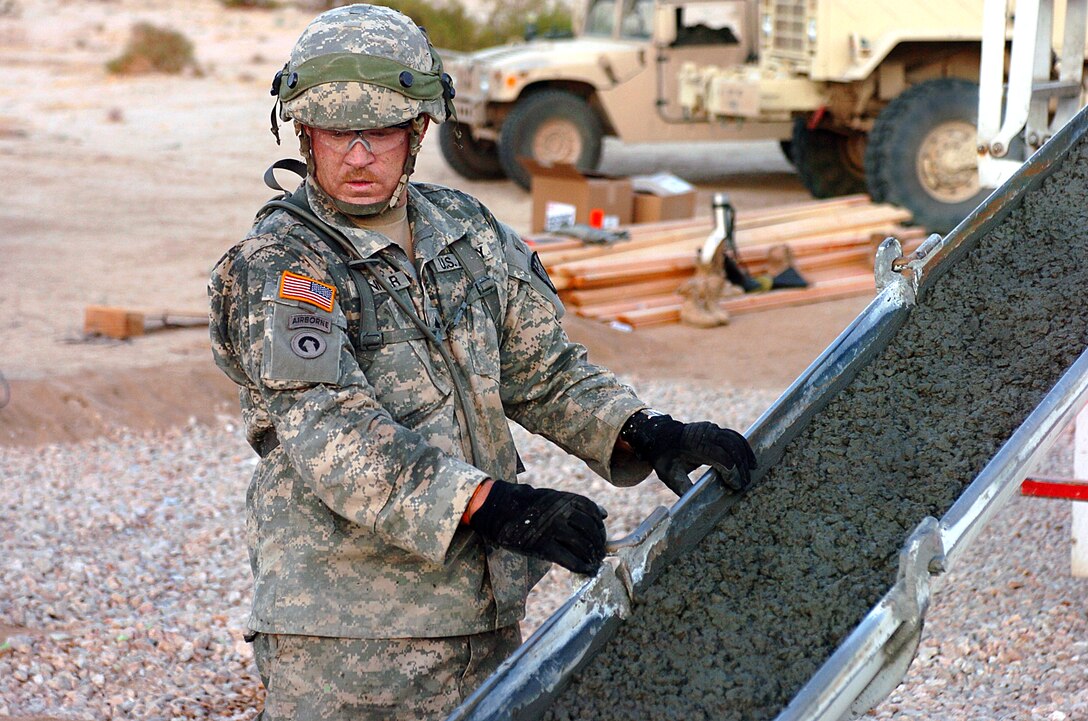 U.S. Army Sgt. Jeremy D. Danner keeps an eye on the flow of concrete as it is unloaded to construct a new helicopter landing pad at the National Training Center in the Mojave Desert, Fort Irwin, Calif., July 21, 2009. Danner is a carpentry and masonry specialist.