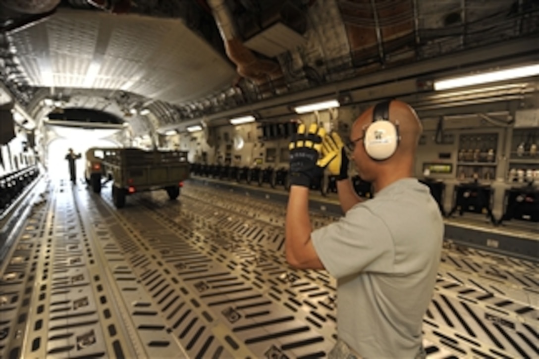 U.S. Air Force Staff Sgt. Michael Gogue marshals a Humvee into a C-17 Globemaster III aircraft during engine running on/off competition at Air Mobility Command Rodeo 2009 at McChord Air Force Base, Wash., on July 20, 2009.  The engine running on/off competition is a timed event intended to simulate an expedient on/offload of cargo in a wartime environment by a five-member team.  Rodeo is an international combat skills and flying operations competition designed to develop and improve techniques and procedures with the international partners of the United States to enhance mobility operations.  Gogue is with the 732nd Air Mobility Squadron, Elmendorf Air Force Base, Alaska.  