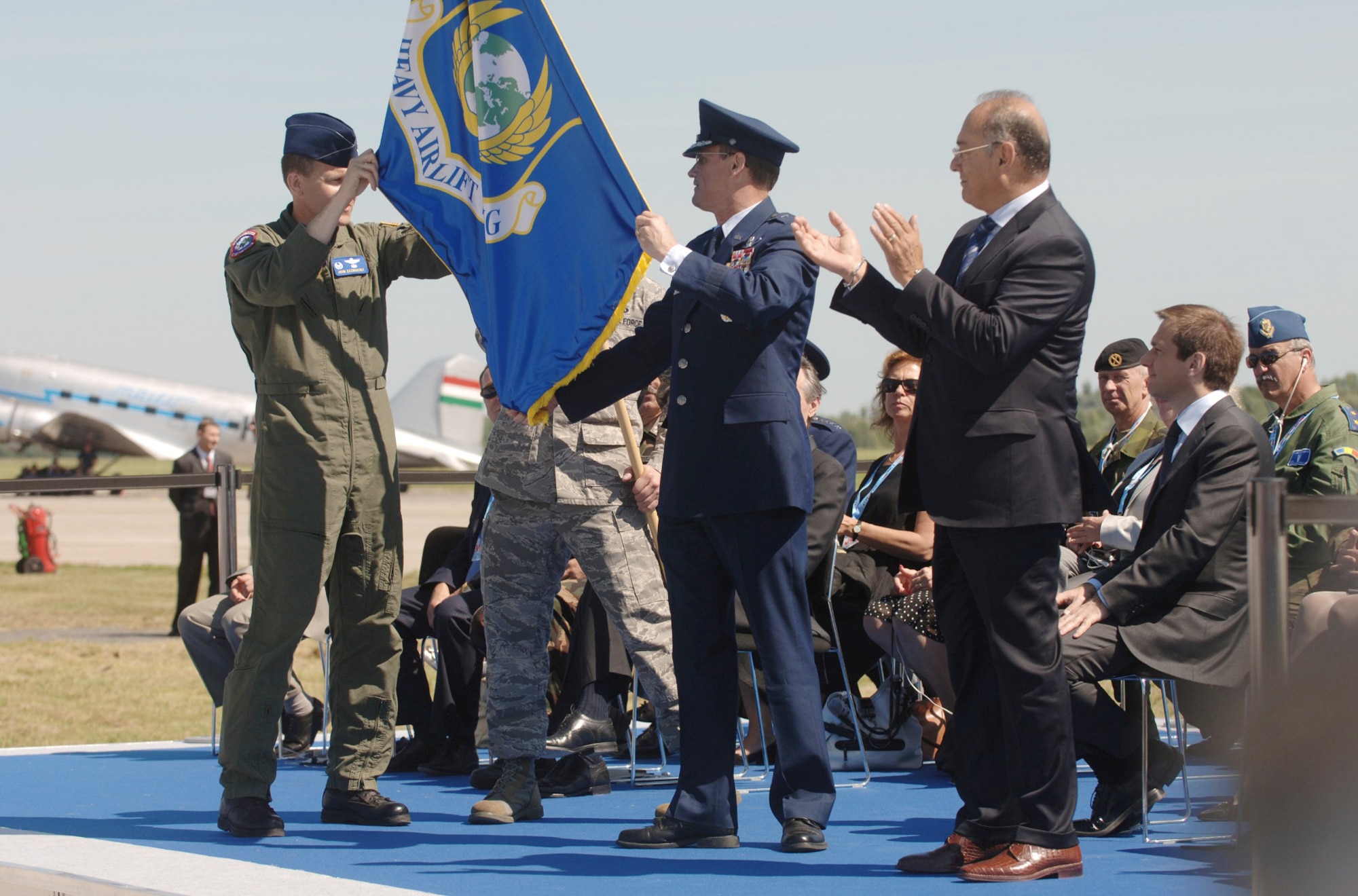 During the official activation ceremony of a first-of-its-kind multinational heavy airlift wing at Papa Air Base, Hungary, July 27, 2009 U.S. Air Force Col. John Zazworsky and Brig. Gen. Richard Johnston unveil the organizational flag. The ceremony celebrated the efforts of the 12 nations who, during the last 10 months, stood up the organization that will provide strategic airlift worldwide for humanitarian, disaster relief, and peacekeeping missions in support of the European Union, United Nations and NATO. (U.S. Air Force photo/Master Sgt. Scott Wagers)