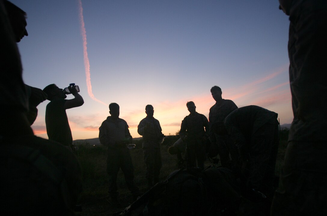 Marines with Company G gather to discuss their plans as a support-by-fire element before conducting a live-fire raid here July 26. The raid was held by Battalion Landing Team 2/4 as part of its second training period at sea before deploying with the 11th Marine Expeditionary Unit later this year.
