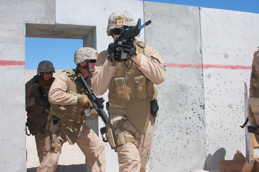 Military policemen with the Combat Center's Provost Marshal's Office's Special Reaction Team charge into a room at Combat Center Range 111 July 29, when they conducted training for military operations in urban terrain.