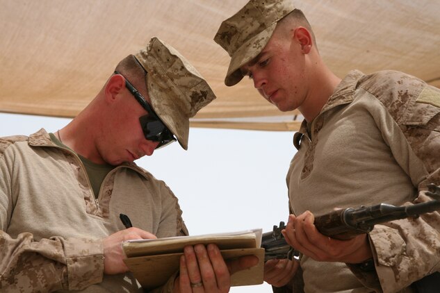 Lance Cpl. David P. Musser, a heavy equipment mechanic with Engineer Ordnance Maintenance Platoon, Maintenance Company, 2nd Supply Battalion Reinforced, 2nd Marine Logistics Group (Forward), reports the serial number of a captured enemy weapon to Lance Cpl. Robert J. Simon, an armorer with EO Maint. Platoon, at the Taji National Maintenance Depot aboard Camp Taji, Iraq, July 28, 2009.  The depot is responsible for destroying unserviceable weapons and turning over serviceable weapons to the Iraqi government to support the Iraqi Army. (U.S. Marine Corps photograph by Cpl. M. M. Bravo)
