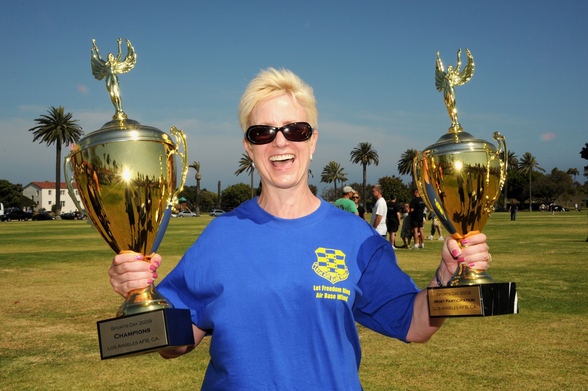 Col. Anita Latin, 61st Air Base Wing commander, holds the wing’s SMC Sports Day trophies, July 24. The 61st Air Base Wing took the overall event team title and had largest number of participants. (Photo by Joe Juarez)