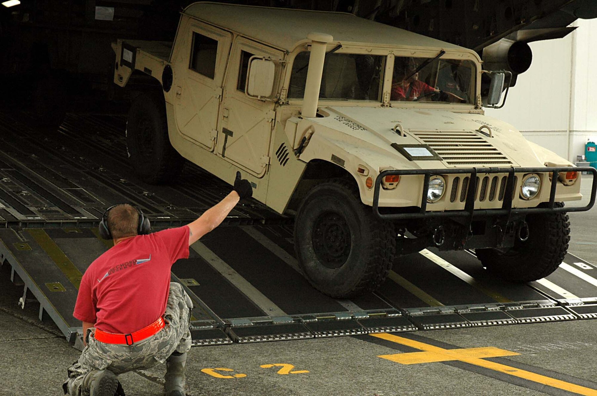 Staff Sgt. Ben Thomsen, 446th Airlift Wing Rodeo Aerial Port team, gives a thumbs up, signaling teammate Tech. Sgt. Dale Bucklin  that he is clear to onload a Humvee with a trailer onto a C-17 during the Engine Running Onload/Offload event at the 2009 Rodeo competition which occurred at McChord Air Force Base, Wash., July 19-24.  (Air Force photo/Airman 1st Class Patrick Cabellon)