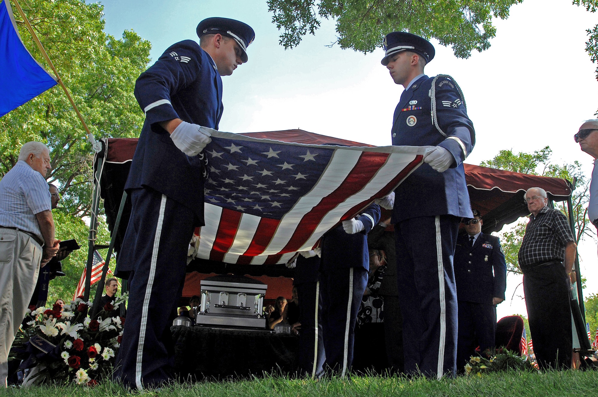 Airmen from the Whiteman Air Force Base Honor guard fold a flag July 27 to honor Chief Master Sgt. Quincy Adam at Chapel Hill Memorial Cemetery. Chief Adam is a Vietnam War veteran who was missing in action for more than 40 years. Chief Adam's remains were discovered in Southeast Asia, and he was finally brought home to be laid to rest, giving his family closure in their lives. (U.S. Air Force photo/Senior Airman Kenny Holston)