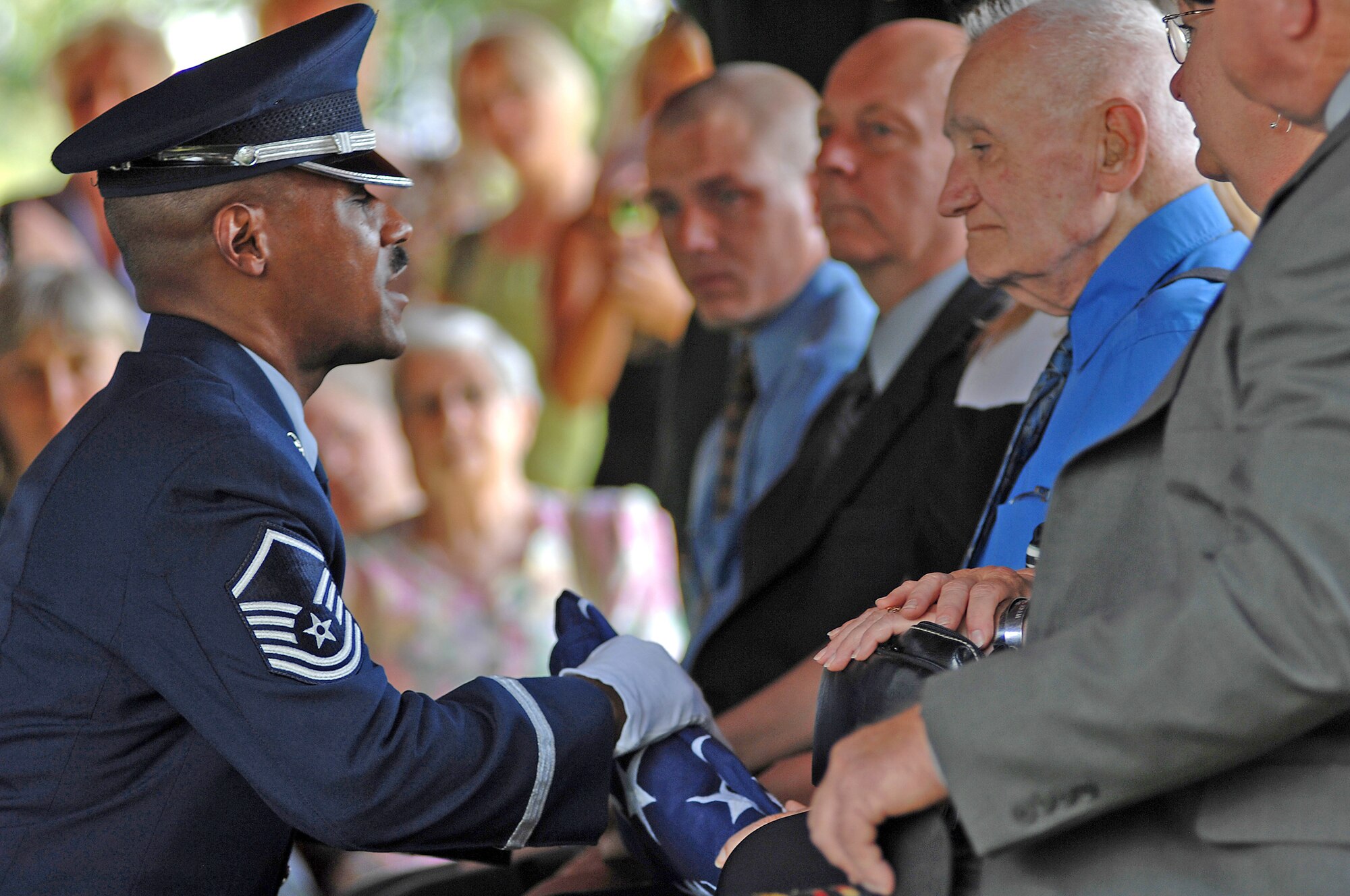 Master Sgt. Gregory Giles presents a folded U.S. flag to Kenneth Adam, father of Chief Master Sgt. Quincy Adam, at Chapel Hill Memorial Cemetery, July 27. Chief Adam is a Vietnam War veteran who was missing in action for more than 40 years. Chief Adam's remains were discovered in Southeast Asia, and he was finally brought home to be laid to rest, giving his family closure in their lives. Sergeant Giles is the Whiteman Air Force Base Honor Guard senior leader. (U.S. Air Force photo/Senior Airman Kenny Holston) 