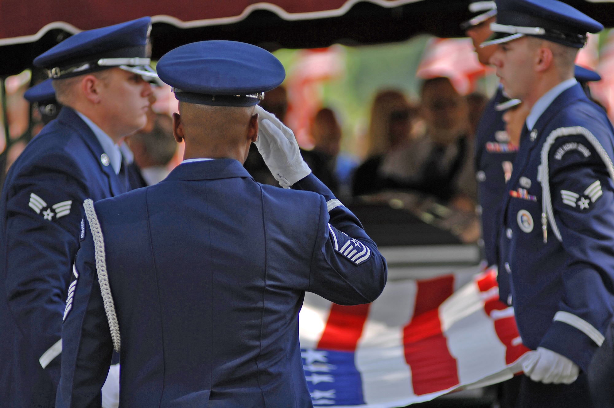Master Sgt. Gregory Giles renders a salute as the rest of the honor guard folds the American flag to be presented to the father of Chief Master Sgt. Quincy Adam at Chapel Hill Memorial Cemetery July 27. Chief Adam is a Vietnam War veteran who was missing in action for more than 40 years. Chief Adam's remains were discovered in Southeast Asia, and he was finally brought home to be laid to rest, giving his family closure in their lives. Sergeant Giles is the Whiteman Air Force Base Honor Guard senior leader. (U.S. Air Force photo/Senior Airman Kenny Holston)