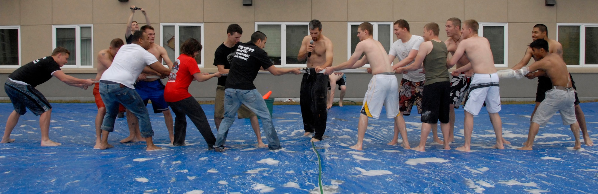 ELMENDORF AIR FORCE BASE, Alaska -- Dan Evans readies two teams for a tug o' war challenge on the slip-n-slide tarp July 25. Tug o' war was one of the many activities held at the Airman's Appreciation Barbecue. Dan Evans is the base chapel's young adult ministry director. (U.S. Air Force photo/Senior Airman Cynthia Spalding)