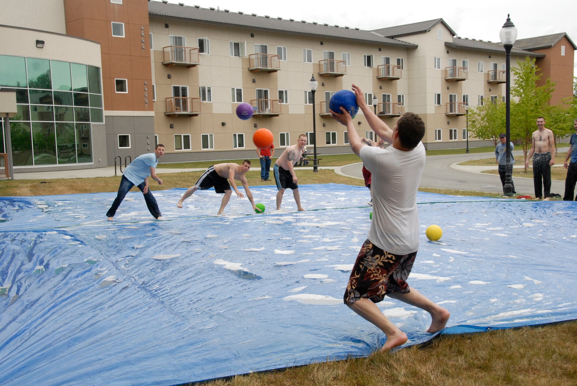 ELMENDORF AIR FORCE BASE, Alaska -- Airman 1st Class Paul Helms catches a ball against the opposing team, out-numbered 3-1, during a game of slip-n-slide dodge ball at the dormitories July 25. More than 100 Airmen participated in outdoor activities held during the Airman's Appreciation Barbecue.Helms is with the 3rd Aircraft Maintenance Squadron.(U.S. Air Force photo/Senior Airman Cynthia Spalding)