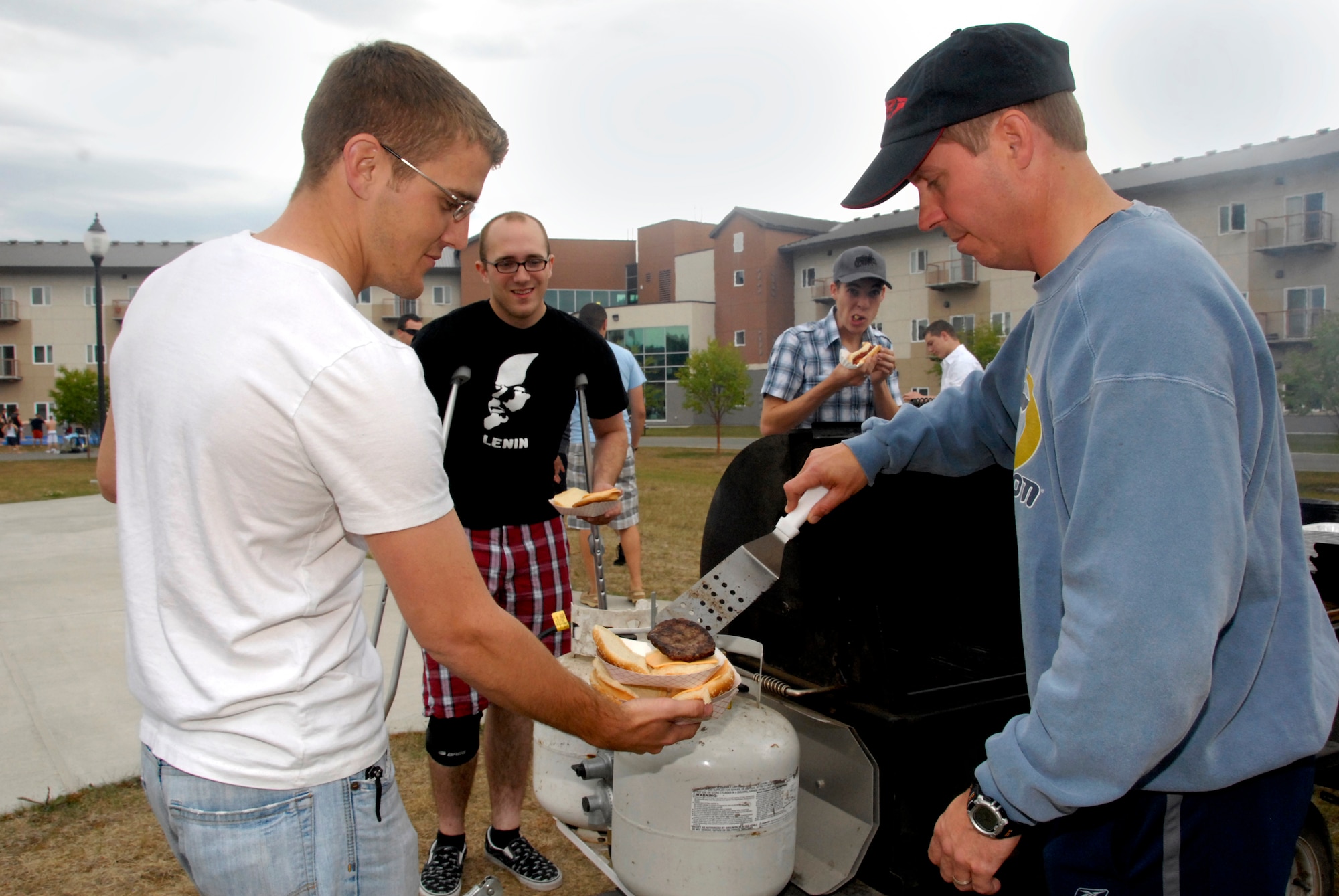 ELMENDORF AIR FORCE BASE, Alaska -- Col. Thomas Bergeson hands Airman 1st Class Mark Gurnsey a hamburger fresh off the grill during the Airman's Appreciation Barbecue July 25. More than 100 Airmen showed up for food and games during the Wired Café's grand re-opening. Bergeson is the 3rd Wing commander and Guernsey is with the 3rd Aircraft Maintenance Squadron. (U.S. Air Force photo/Senior Airman Cynthia Spalding)