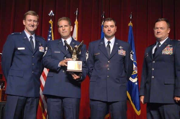 From left to right, Lt. Col. Tom Jensen, Chief Master Sgt. Jim Masura, Master Sgt. Scott Dellinger and Col. Dave Pavey, 446th Operations Group commander, pose with the Aircrew Excellence Award which was given to the crew from the 446th Airlift Wing, Joint Base Lewis-McChord, Washington, at the 11th Annual Raincross Trophy dinner held July 23, 2014, at the Riverside Convention Center, Riverside, California. The dinner is hosted by the Greater Riverside Chambers of Commerce Military Affairs Committee to honor and recognize the 11 wings and two groups in 4th Air Force. (U.S. Air Force photo/Senior Master Sgt. Kim Allain) 

