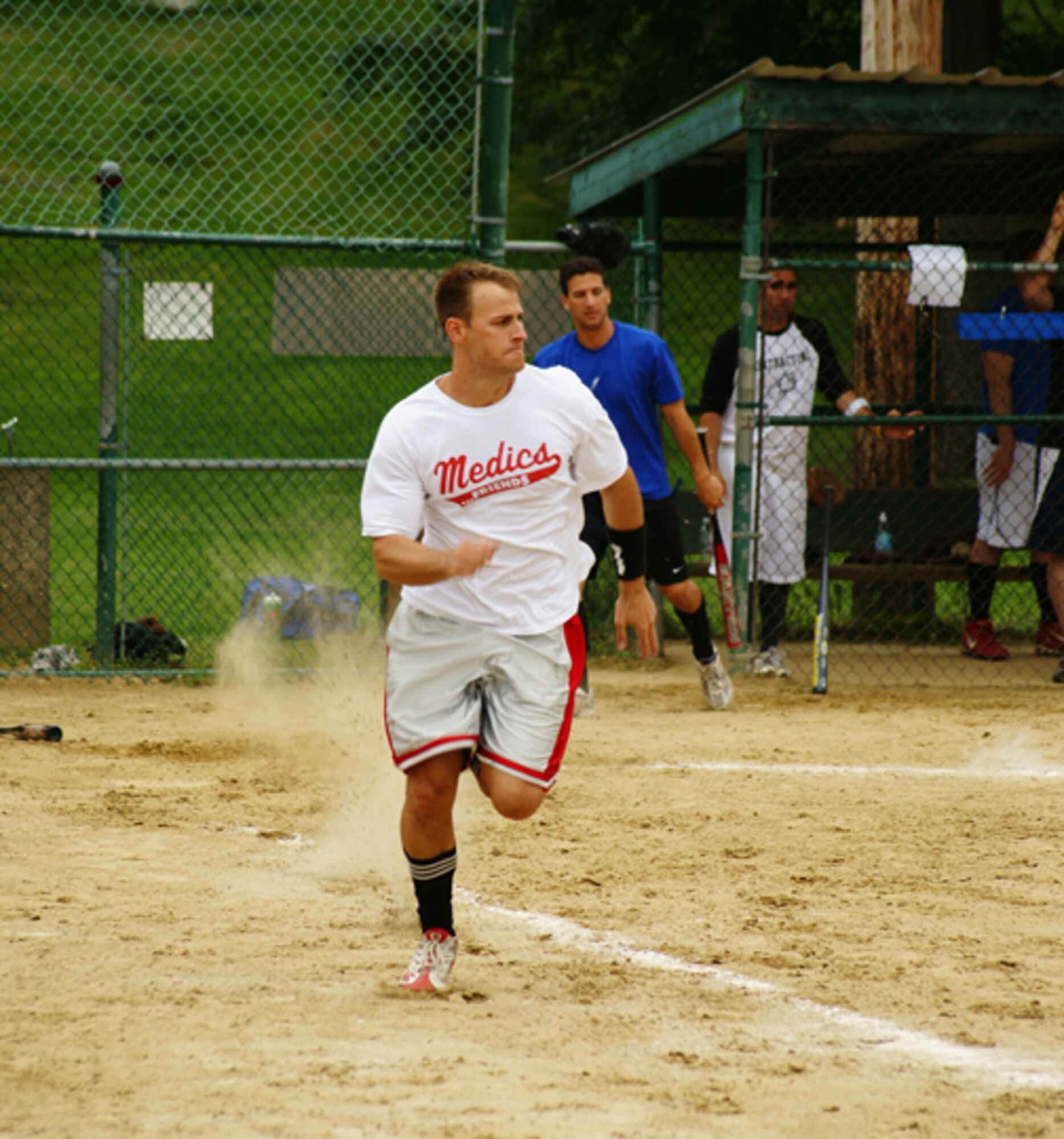 Capt. Mike Elliot, 66th Medical Operations Squadron, makes a run for first base as 2nd Lt. Frank Shiavone, 66th Contracting Squadron, prepares for his turn at bat  during a company grade officers vs. colonels and Top 3 softball game on July 15. (Courtesy photo by 1st Lt. Chris Wenz)