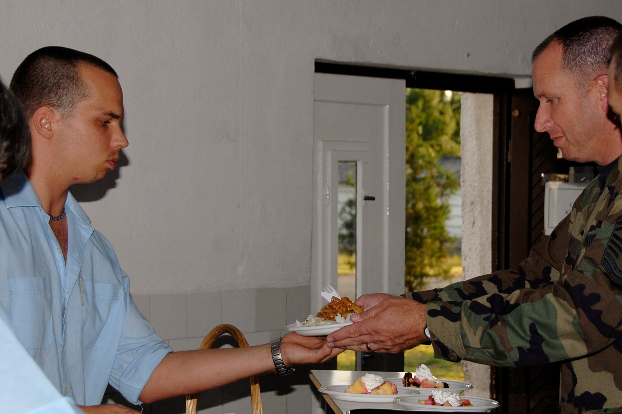 Senior Master Sgt. Phil Trusty of the Minnesota Air National Guard is served his first meal in ?jd?r?gd, Hungary on July 20, 2009 where he and about forty other members from the 133rd Airlift Wing?s Civil Engineering Squadron conducted a two week Deployment for Training.  USAF photo by Staff Sgt. Amber Monio.