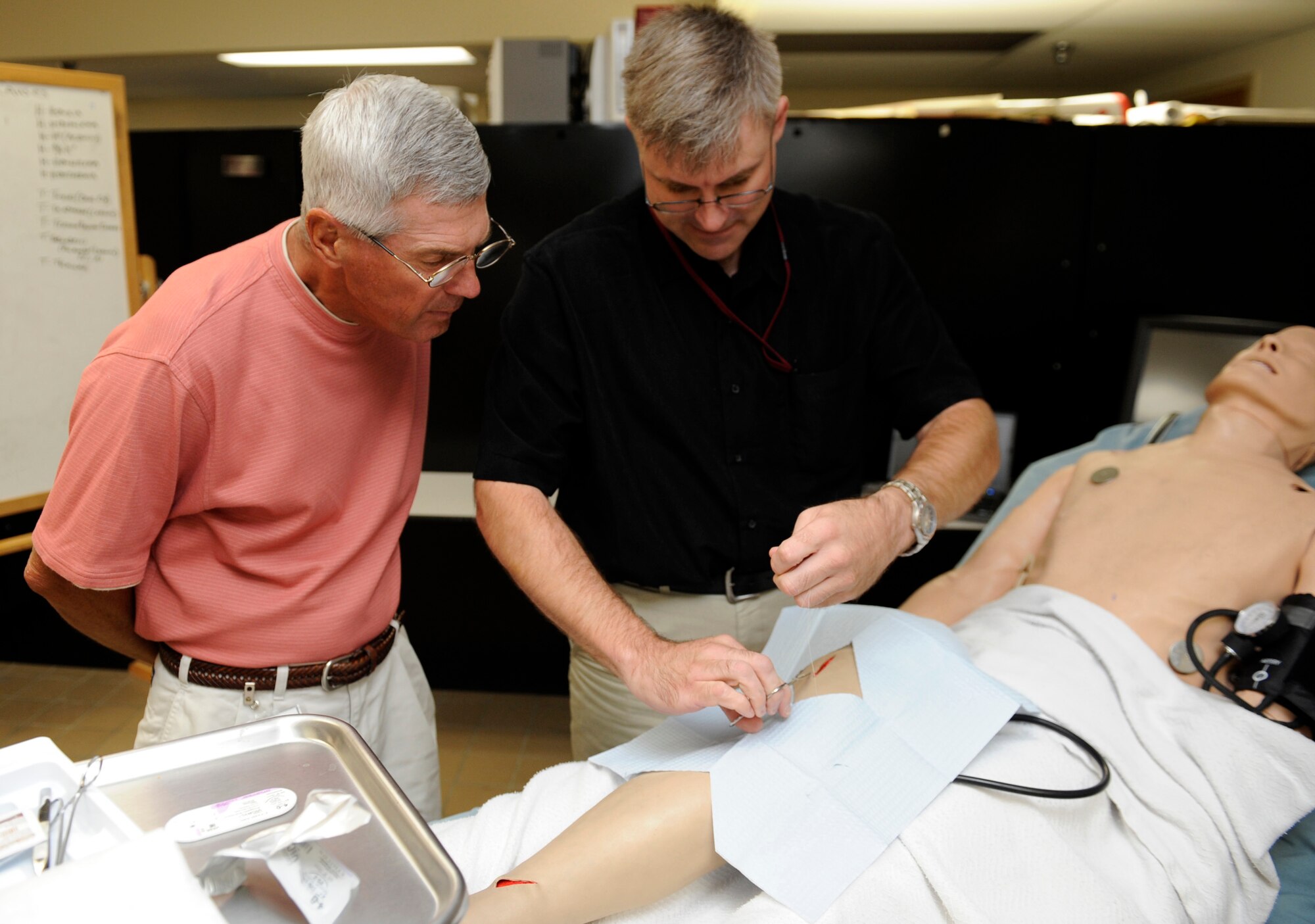 MOUNTAIN HOME AIR FORCE BASE, Idaho -- Steven Walker, 366th Fighter Wing life support program manager, demonstrates how to stitch a wound while Timothy Franks, Pioneer Federal Credit Union board chairman and 391st Fighter Squadron honorary commander, watches during the Honorary Commander Medical Group Day at the base hospital July 24. The honorary commanders program is a wing-level program that pairs civic leaders with squadron, group and wing leaders to enhance the relationships between local communities and the base. It also provides a rare glimpse of life on a military installation to members of neighboring communities -- many of whom have no connection to the Air Force or prior knowledge of the military. (U.S. Air Force photo by Airman 1st Class Debbie Lockhart)