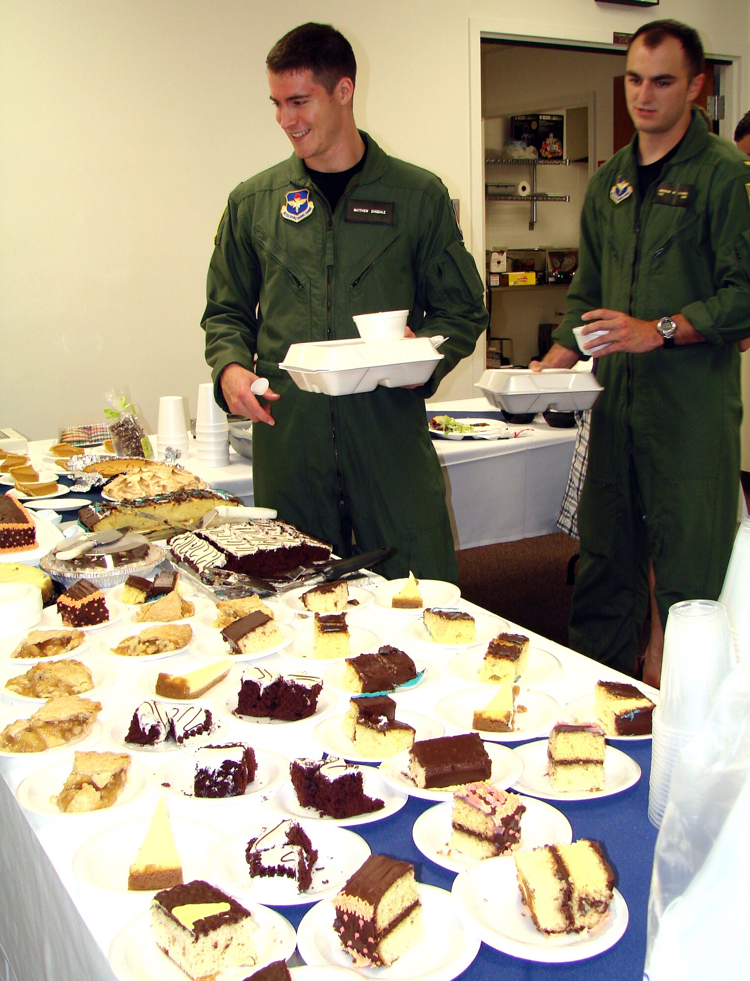 Second Lt. Matthew Dinsdale, left, and Navy Ensign Andrew Conner, both with pilot training Class 10-09, select deserts to go along with their dinner at the Singles’ International Gourmet Meal Opportunity July 27 in the Community Chapel Activity Center. They were among more than 150 singles attending the free monthly meal served by base volunteers. (U.S. Air Force photo/ Joe B. Wiles)