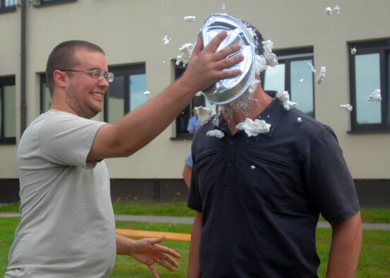 SPANGDAHLEM AIR BASE, Germany -- Senior Airman Steven Underwood, 52nd Operation Support Squadron current intelligence analyst, pies Capt. Ryan Wood, 52nd OSS intelligence weapons officer, in the face during the OSS moral picnic July 27. Once a quarter the 52nd OSS booster club sponsors an event to bring the flights together for a day of friendly competition, food, an inflatable castle, a tug-o-war contest. (U.S. Air Force photo by Senior Airman Jenifer H. Calhoun)