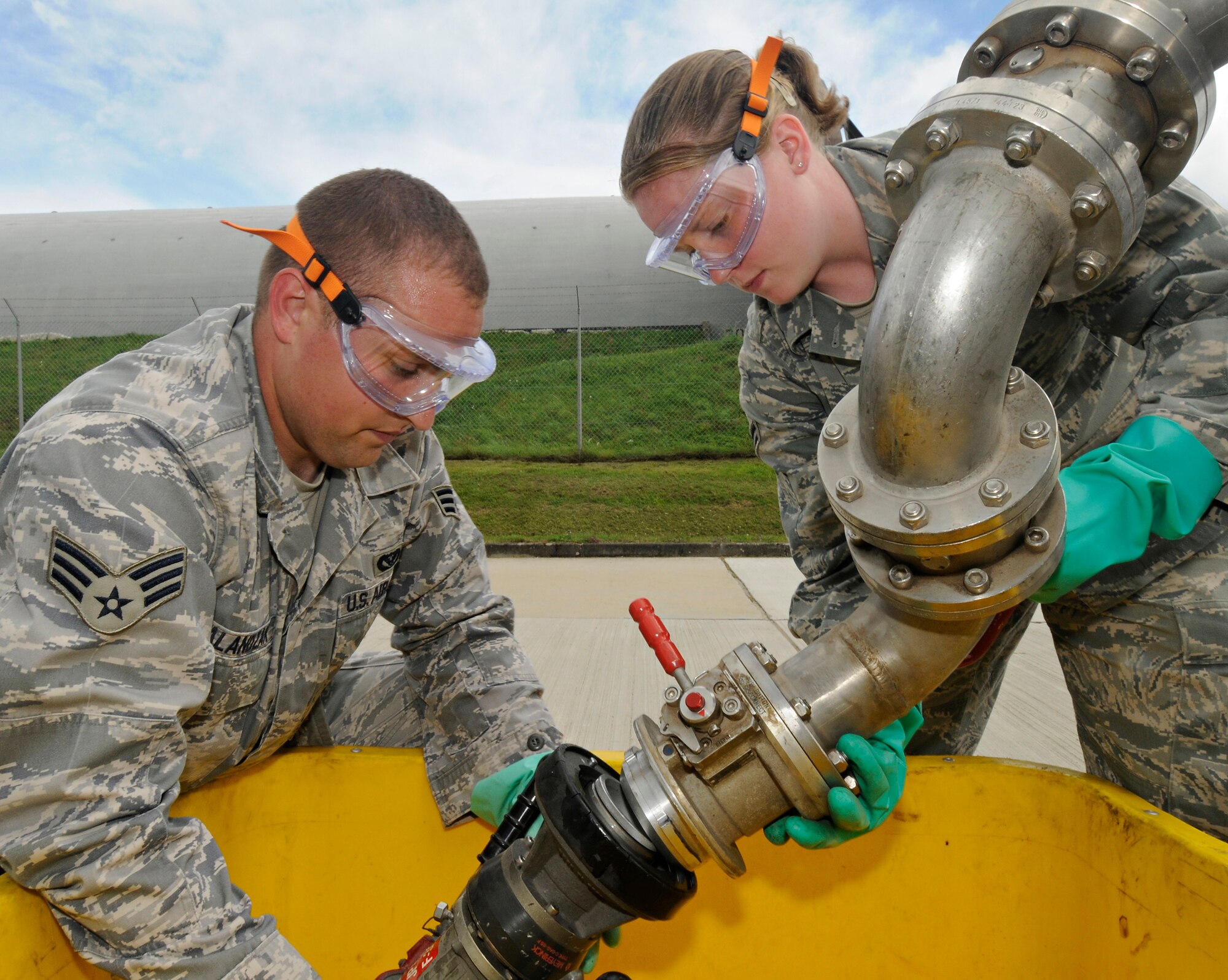 SPANGDAHLEM AIR BASE, Germany – Senior Airman Ivan Alandzak and Airman 1st Class Jennea Allen,  52nd Civil Engineer Squadron, replace a single point nozzle over a drip-pan on one of Spangdahlem Air Base’s truck refueling stands July 23. The 52nd CES Liquid Fuels Flight changes and repairs the nozzles when there is damage or a leak. The liquid fuels flight manages 2,300 meters of fuel pipeline, 23 underground fuel tanks and 8.2 million gallons of JP-8. (U.S. Air Force photo by Senior Airman Benjamin Wilson)