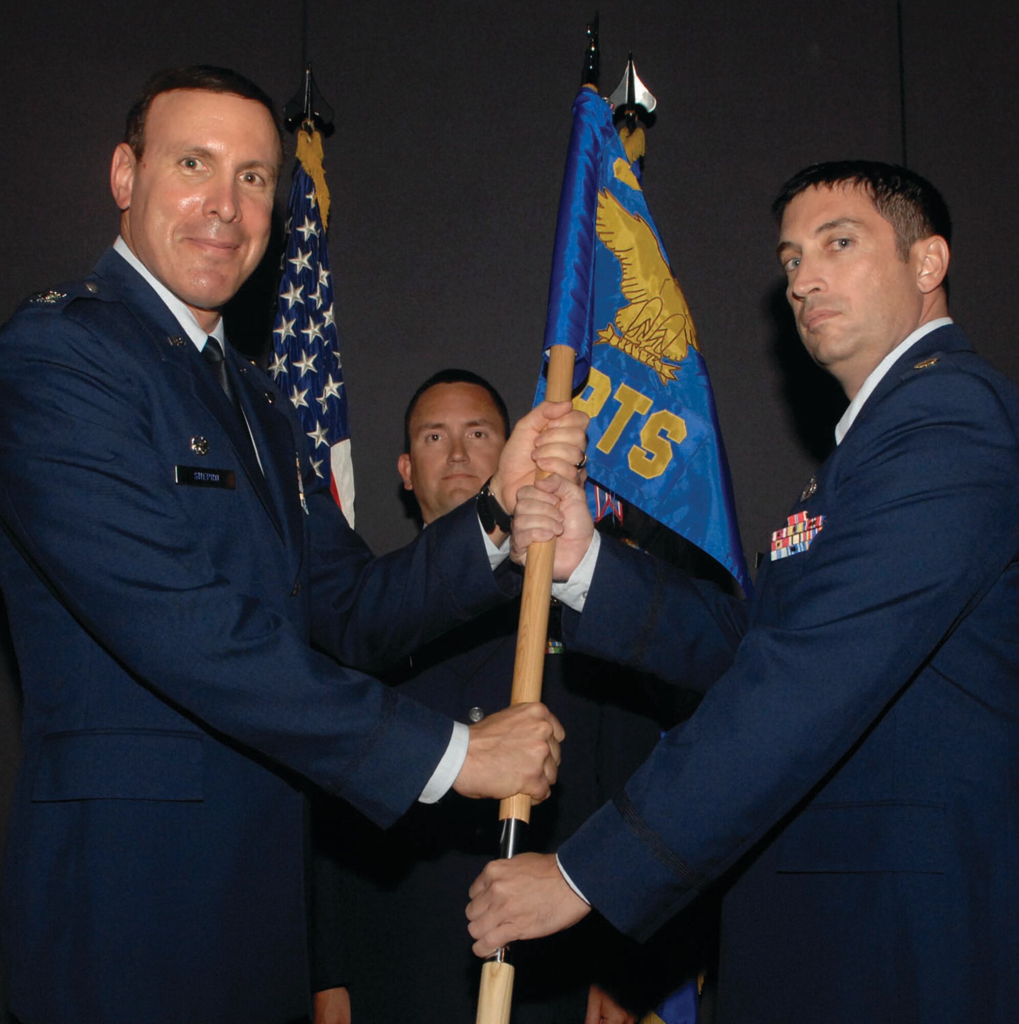 Colonel Steven Shepro, 316th Wing/Andrews commander, passes the guidon to Maj. William Martin, 316th Comptroller Squadron commander, during his change of command at Andrews July 17. (U.S. Air Force photo/ Staff Sgt. Melissa Stonecipher)