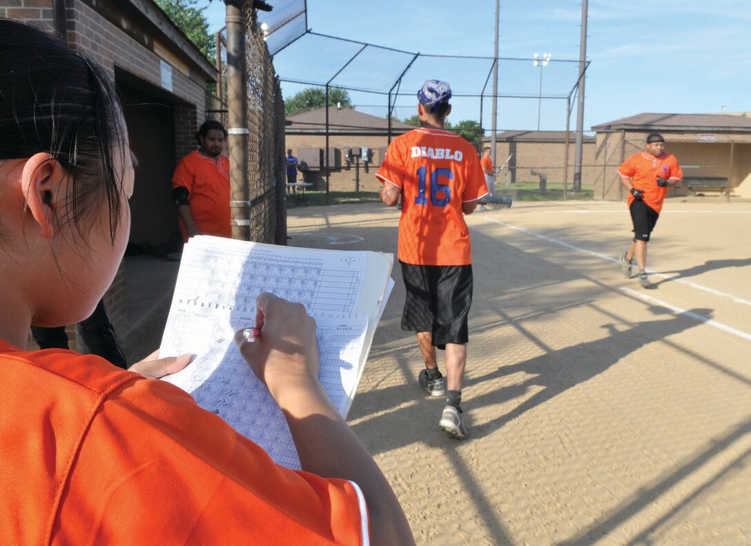 Chris Williams, 779th Surgical Operations Squadron, runs to first base while Jessica Huynh, 779th Medical Support Squadron, updates the stats sheet and Adam Delgado, 779th Medical Operations Squadron, prepares to take the plate at the softball field July 14. The 779th Medical Group played the Navy VR-53, winning both games, making their record 8-0. (U.S. Air Force photo/ Senior Airman Renae Kleckner)