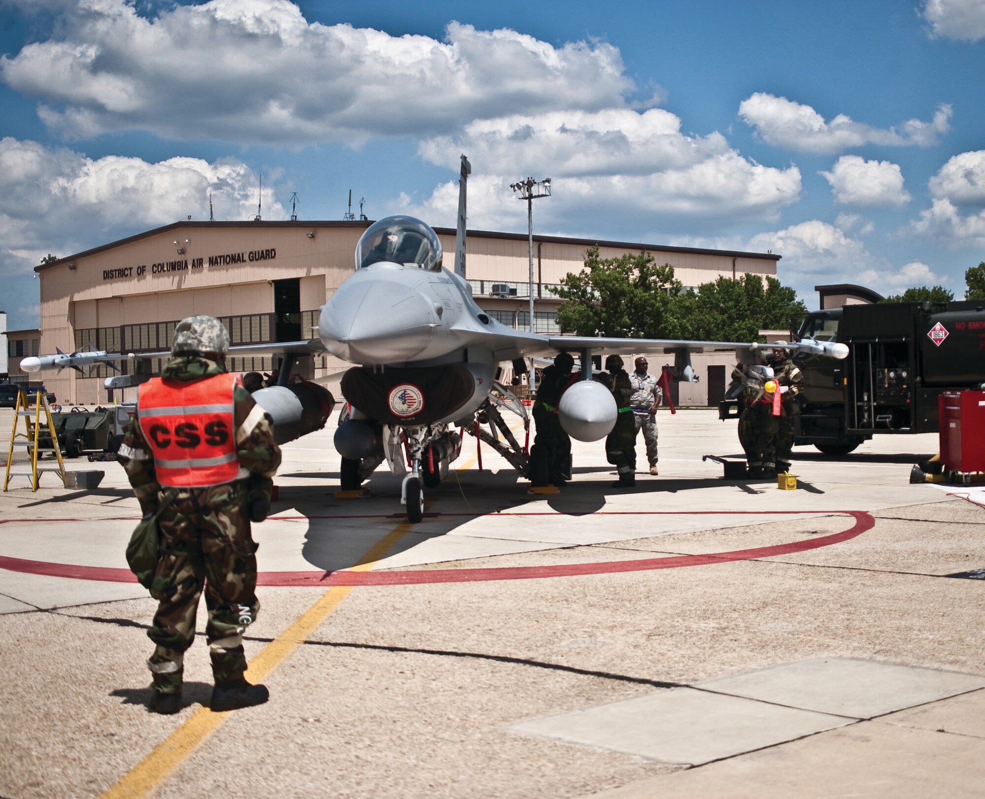 113th Maintenance Squadron crew chiefs, weapons loaders and refuelers inspect an F-16C Fighting Falcon, load weapons and standby to refuel recently. The concurrent servicing supervisor, left, ensures safety and proper procedures are followed. (U.S. Air Force photo/ Master Sgt. Dennis Young)