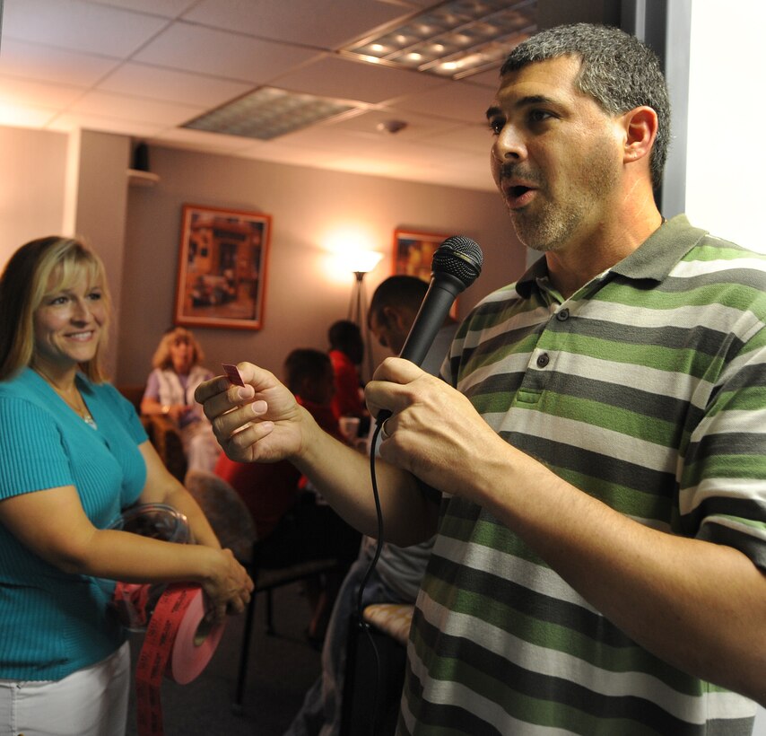 LANGLEY AIR FORCE BASE, Va. -- Rich Roberts, young adult ministry coordinator, reads the winning number on a ticket while his wife, Justine, watches during a door prize drawing as part of the re-opening ceremony for the Eagle's Wing at the Career Development building July 23. The Eagle's Wing is considered a "safe haven" for many Airmen looking for a place to eat, hang out, attend Bible studies, and interact with others through video games and poker nights. (U.S. Air Force photo/Airman Rebecca Montez)
