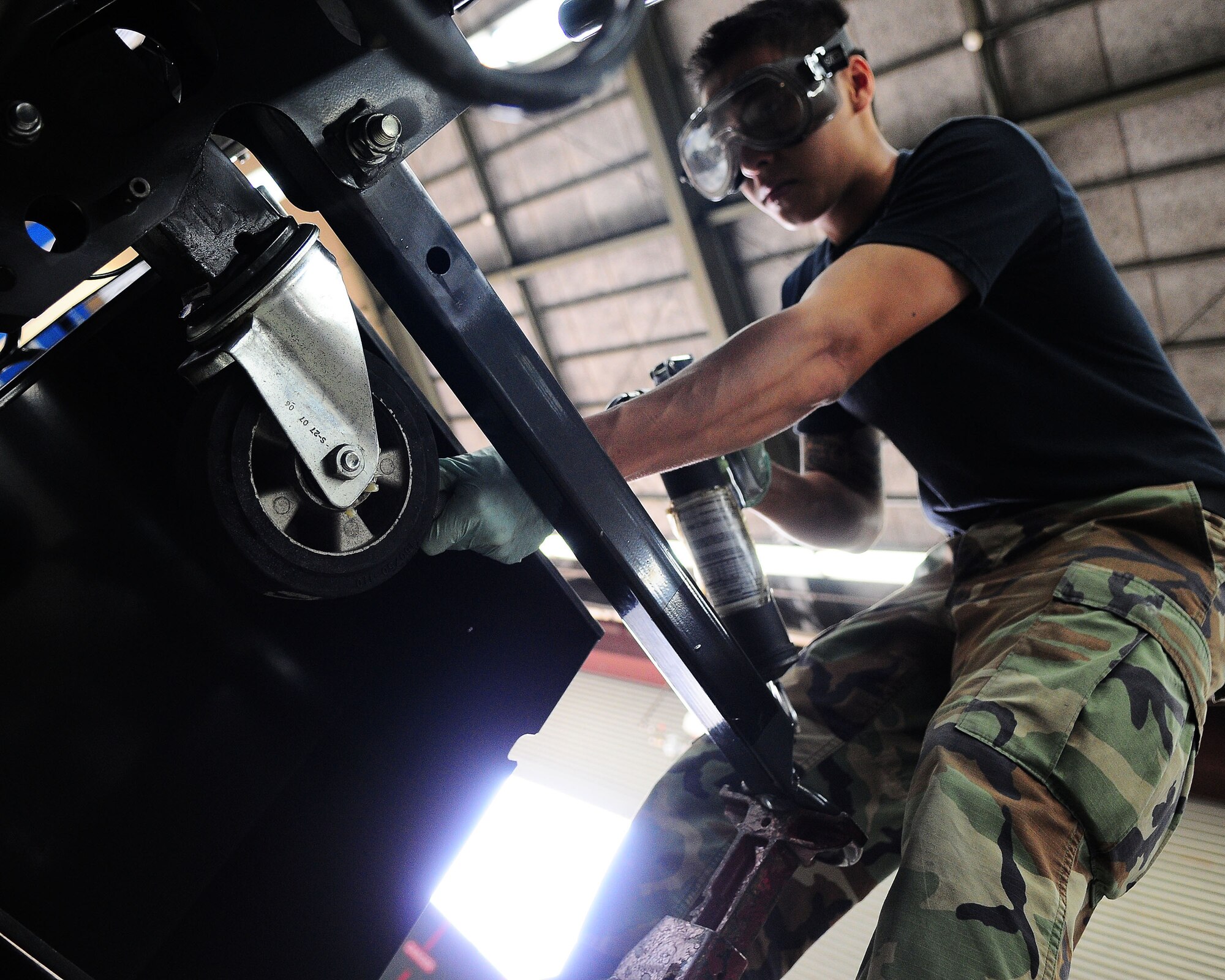YOKOTA AIR BASE, Japan -- Airman 1st Class Nicholas Trans, 374th Maintenance Squadron Aerospace Ground Equipment Flight, works on an aircraft nose cone dolly July 23. Members of the AGE flight support the base's flying mission by maintaining more than 600 pieces of ground support equipment. (U.S. Air Force photo/Airman 1st Class Michael Dillon)