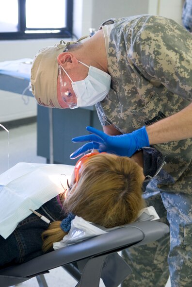 U.S. Army Captain Gustavo Gonzalez, Texas Medical Command works with a new patient at the Dental room during Operation Lone Star at Raul A. Besteiro Jr. Middle School. Operation Lone Star is a joint civilian/military medical mission offering free medical and dental care  in Brownsville,Texas, 27 July 2009.(USAF Photo by Master Sgt. Michael Lachman)  