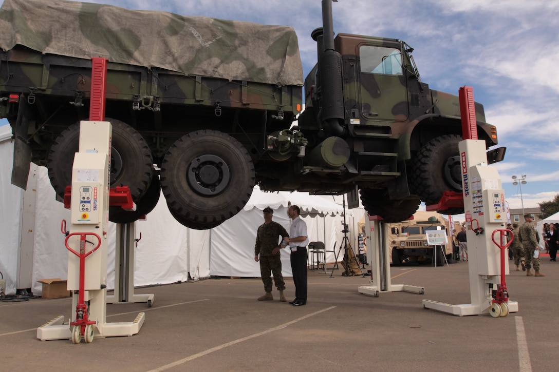 Carl Boyer, Stertil-Koni sales representative, gives a demonstration of the Stertil-Koni Mobile Column Lift System to Maj. Parke Paulson, project manager Base Communication and Information Systems, on a 7-ton truck at the 2011 Marine West Expo on Camp Pendleton, Jan. 26.  The Expo showcased more than 200 vendors to more than 3,500 visitors and highlighted the best of what deployed Marines are using and will use in years to come.