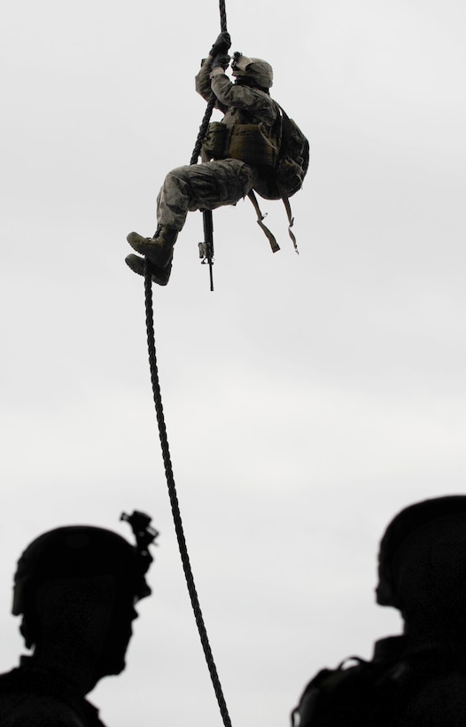 A Marine with Company E, Battalion Landing Team 2/4, descends from a helicopter parked on the flight deck of USS Bonhomme Richard during fast-rope training July 28. Company E, which trains as the team's heliborne infantry company, is deploying with the 11th Marine Expeditionary Unit later this year.