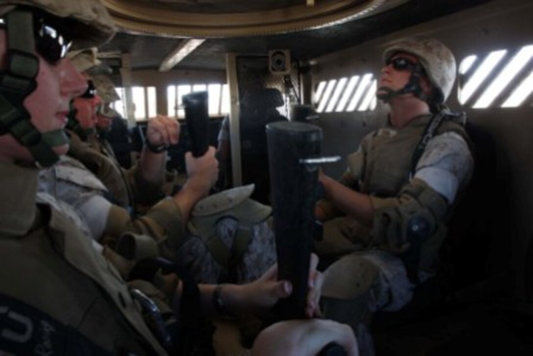 Lance Cpl. Adam D. Lisa, a Logistics Vehicle System operator with Marine Wing Support Squadron 374, takes a deep breath before the Combat Center’s newest rollover training simulator, called Mine Resistant Ambush Protected Egress Trainer, begins spinning at the Battle Simulation Center at Camp Wilson July 30.