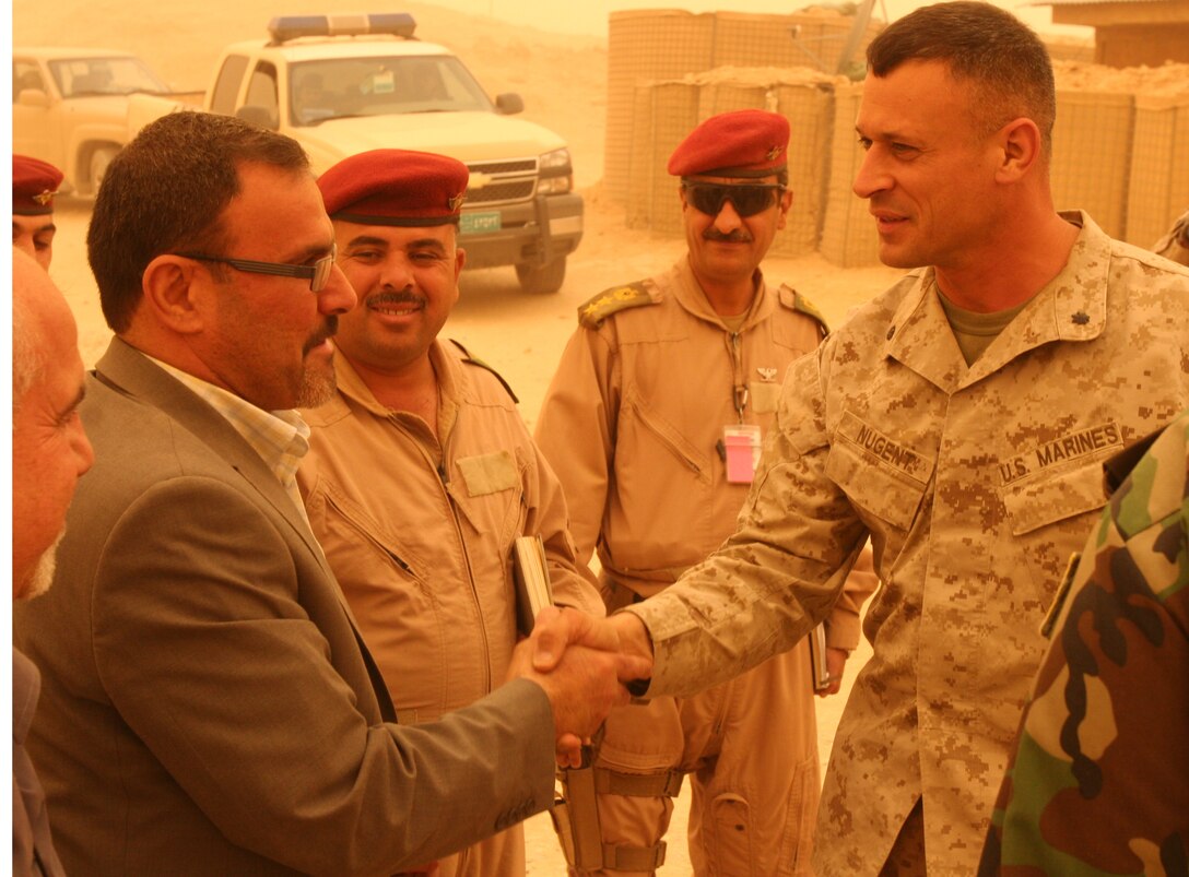 Lt Col. Paul J. Nugent, commanding officer of 2nd Battalion, 1st Marine Regiment, Regimental Combat Team 8, greets Sameer Alhaddad, receivership secretariat and prime minister’s representative for the Government of Iraq, aboard Combat Outpost Rawah before the transfer of the COP, July 29, 2009. The transfer of COP Rawah is a result of the progress Iraqi Security Forces have made in preserving peace and stability throughout Al Anbar province.