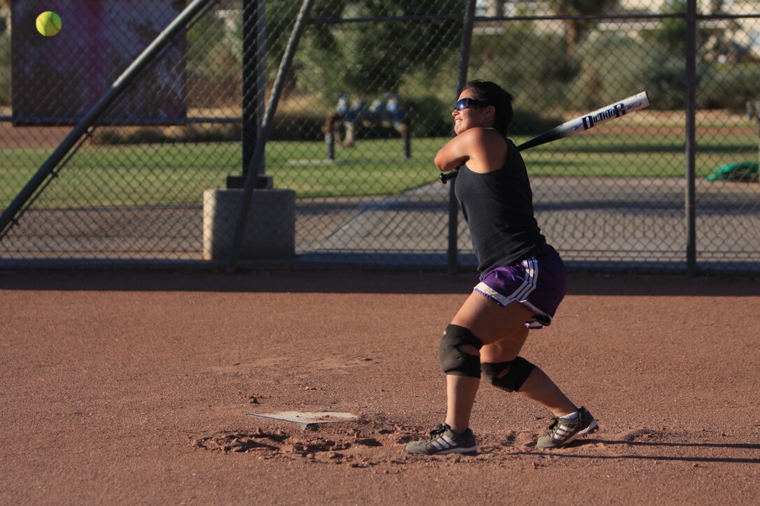 Lance Cpl. Katherine Smith, an administrative clerk at the Installation  Personnel Administration Center, who played with the All-Marine Women's Softball Team in 2007, keeps her eye on the ball in preparation to smash it to the outfield during the All-Marine Women's Softball Team screening July 29 at Felix Field.