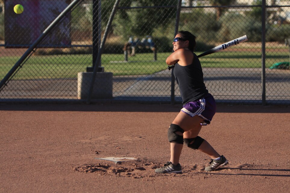 Lance Cpl. Katherine Smith, an administrative clerk at the Installation  Personnel Administration Center, who played with the All-Marine Women's Softball Team in 2007, keeps her eye on the ball in preparation to smash it to the outfield during the All-Marine Women's Softball Team screening July 29 at Felix Field.