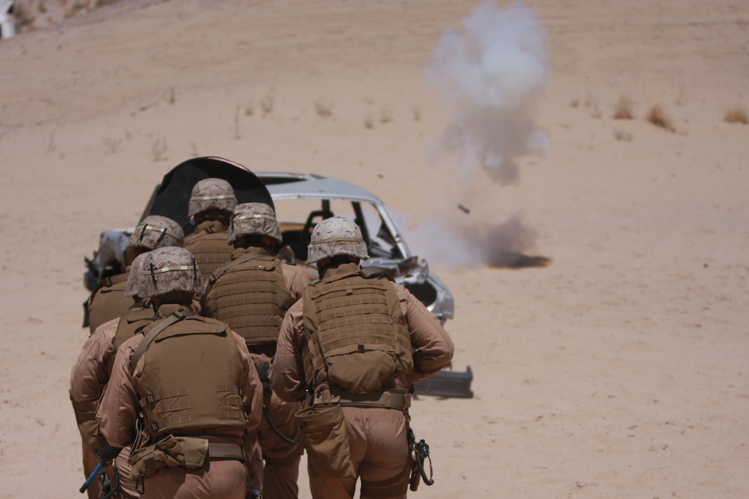 The Combat Center's Provost Marshal's Office Special Reaction Team times their charge on a hostile vehicle with the detonation of a flash bang grenade July 29, outside a structure at Combat Center Range 111.