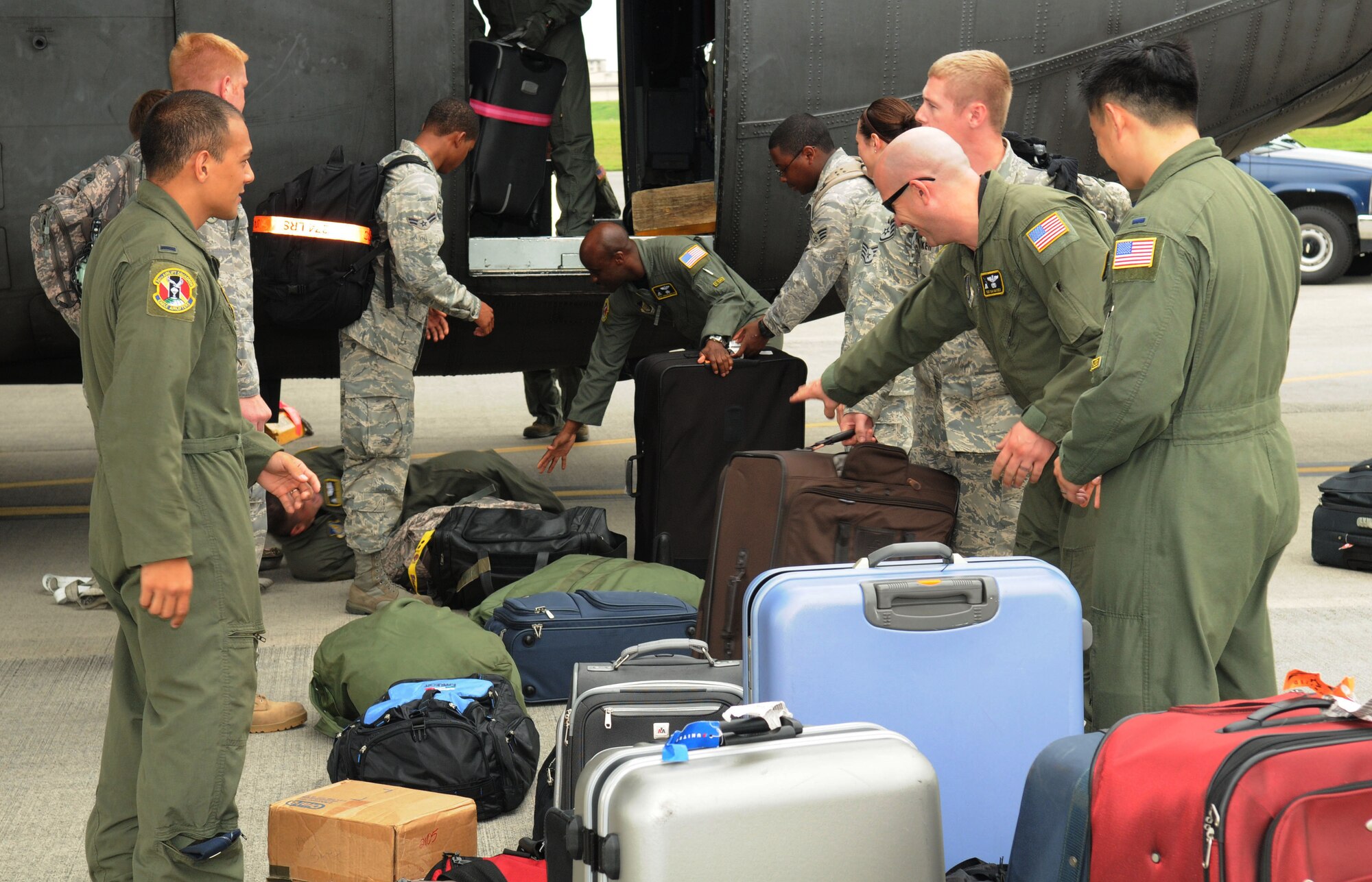 YOKOTA AIR BASE, Japan -- Members of the Yokota maintenance team who brought home the Knuckle Buster Award from the 2009 Air Mobility Command Rodeo receive help with their luggage upon their return to base July 28. The award recognized the maintenance team that displayed the highest professionalism, dedication and mutual respect for their competitors. (U.S. Air Force photo/Airman 1st Class Sean Martin)