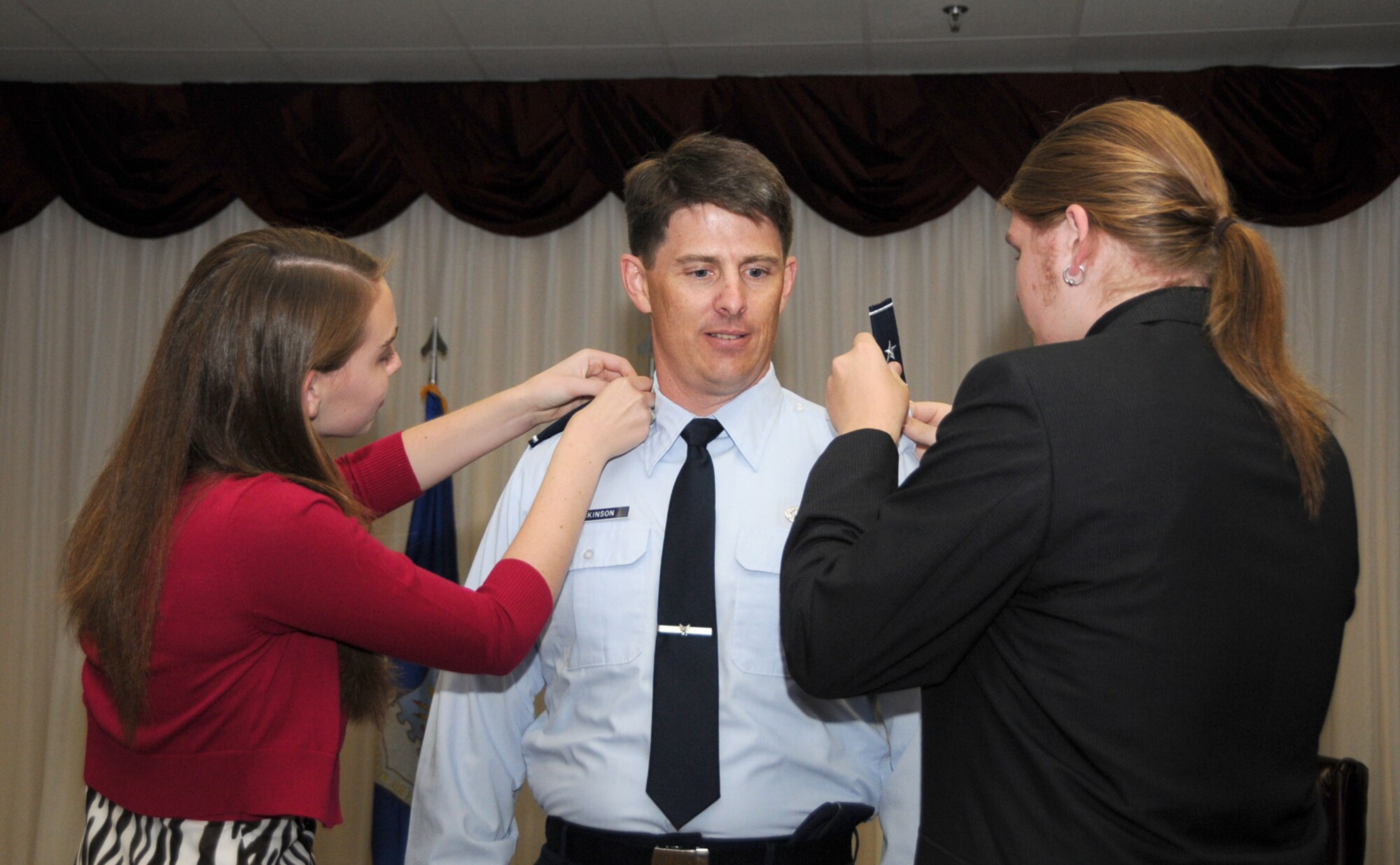 Maggie and Nate Dickinson pin stars on their dad, Brig. Gen. Ian Dickinson, at his promotion ceremony at the Dragon's Lair, July 20.  The general is commander of the 81st Training Wing.  (U.S. Air Force photo by Kemberly Groue)