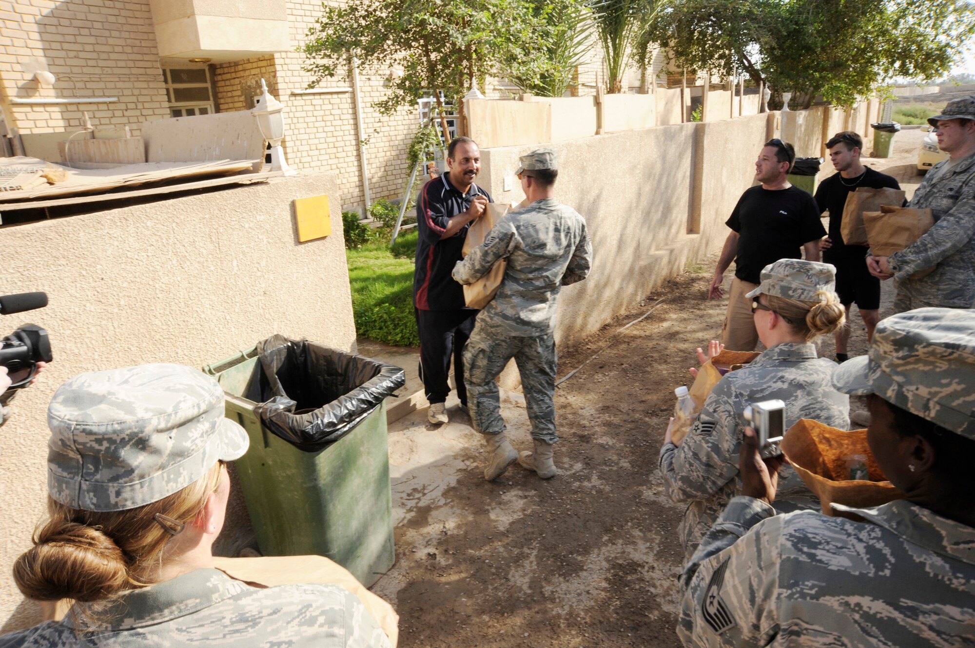 Tech. Sgt. Theodore Tetreault hands donated items to an Iraqi July 24 in Baghdad. Forty-five Airmen and Soldiers volunteered to visit and distribute donated items to local Iraqi families as part of the Sather Air Base Good Neighbor Program. Sergeant Tetreault is a Multinational Corps-Iraq Infrastructure Protection and Reconstruction geo base technician. Sergeant Tetreault is deployed from Nellis Air Force Base, Nevada, and is a native of Cape Cod, Mass. (U.S. Air Force photo/Tech. Sgt. Johnny L. Saldivar) 