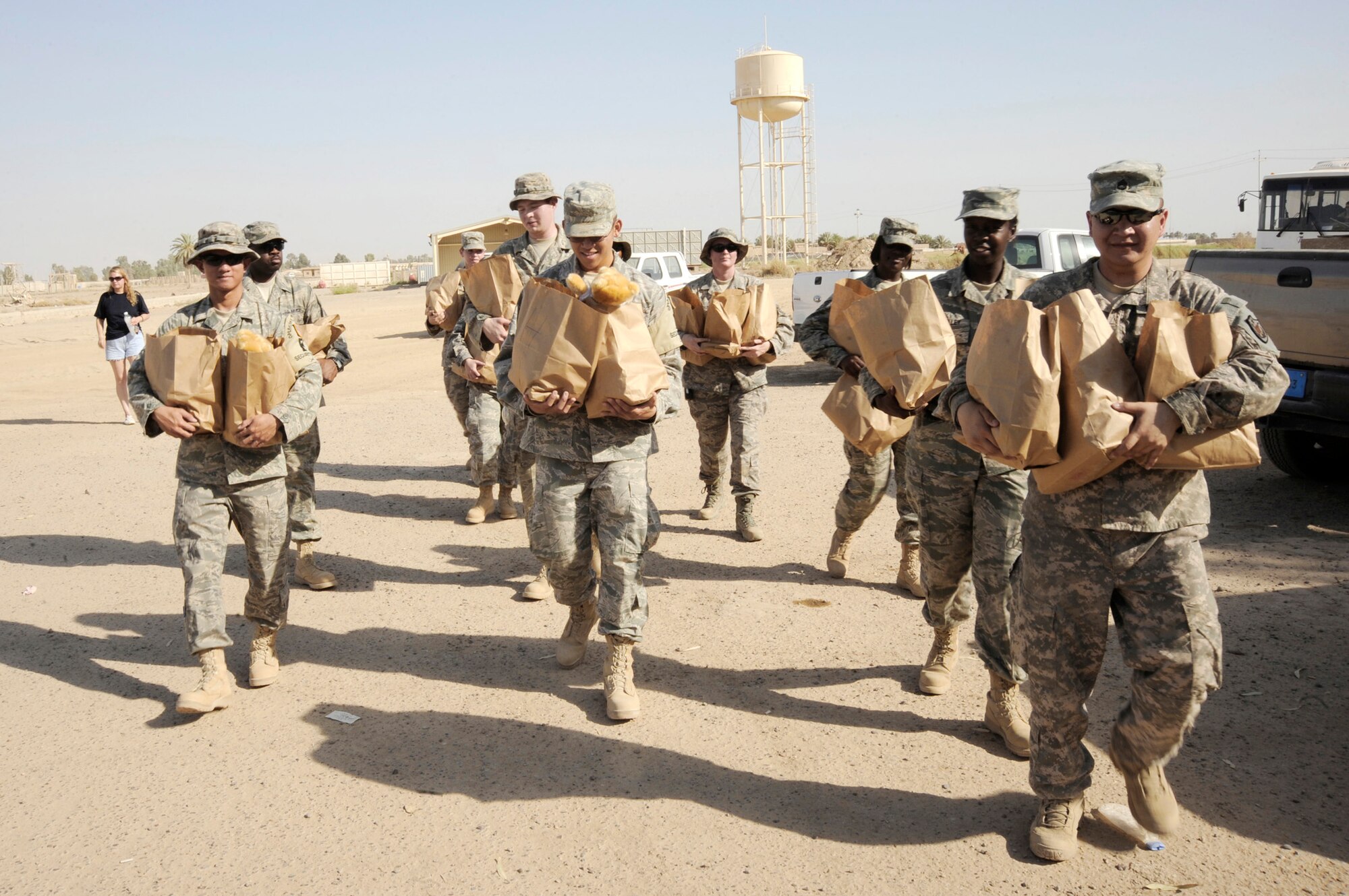 Airmen and Soldiers prepare to deliver goods to local Iraqi families July 24 in Baghdad, as part of the Sather Air Base Good Neighbor Program. This program is made up of volunteers who make a trip once a month to distribute care packages to Iraqi families. The packages include items the Iraqi families may have a hard time getting otherwise, such as personal hygiene items, dry food, toys for children and snacks. (U.S. Air Force photo/Tech. Sgt. Johnny L. Saldivar) 