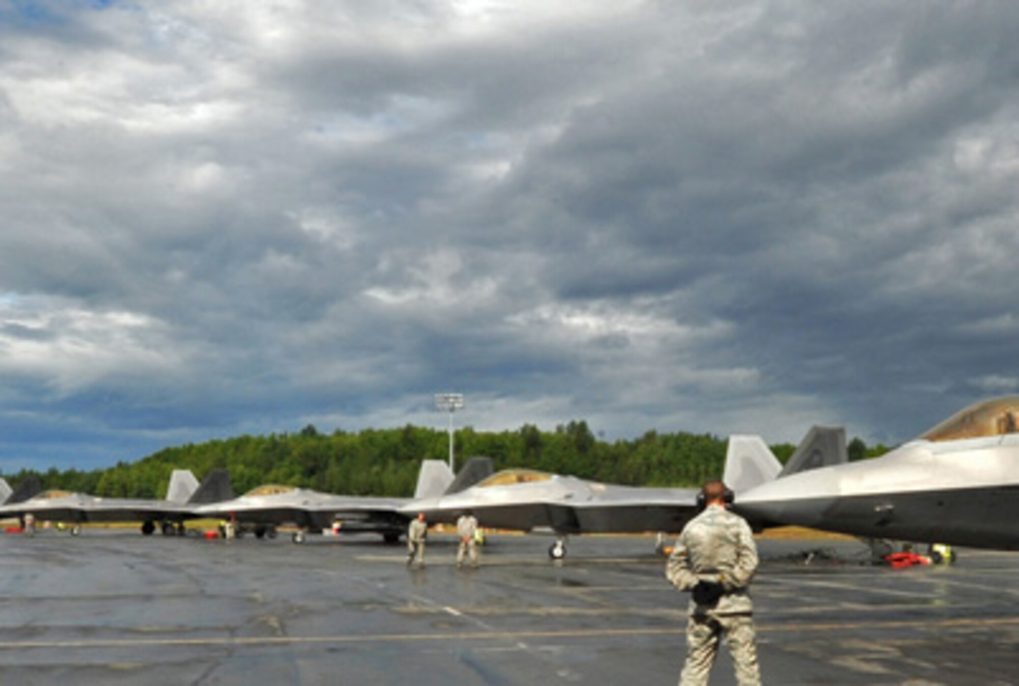 F-22 Raptor pilots wait for maintainers to give the sign to start the mission during a rainy day July 27 at Elmendorf Air Force Base, Alaska for Red Flag-Alaska. Red Flag is a Pacific Air Forces commander-based field training exercise for U.S. coalition forces. (U.S. Air Force photo/Senior Airman Laura Turner)