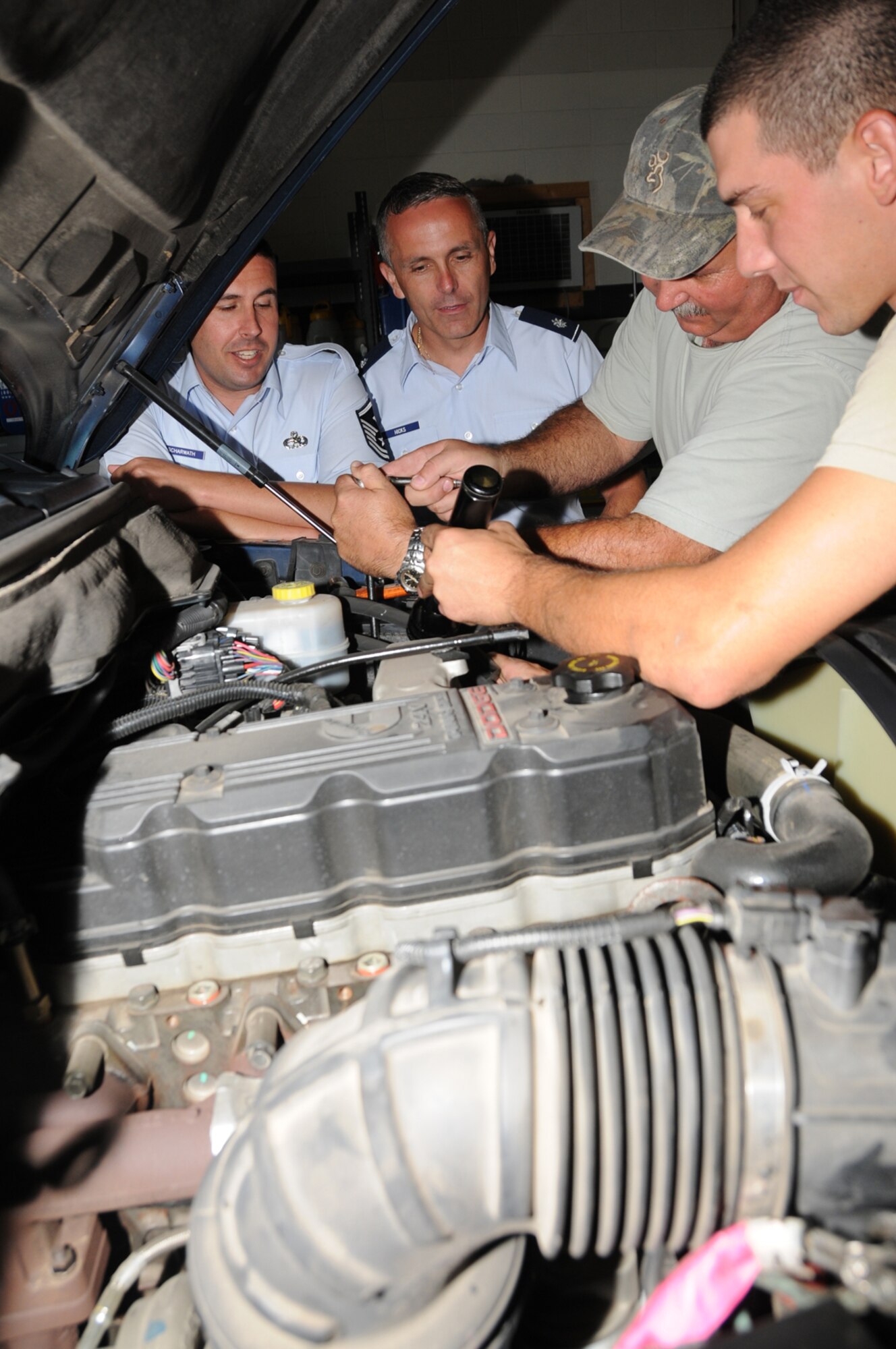 From left, Master Sgt.  Kevin Scharwath, 81st Logistics Readiness Squadron first sergeant, and Lt. Col. Robert Hicks, new 81st LRS commander, watch Tommy Papania and Airman 1st Class 1st Eric Foster perform corrosion control on a battery in the vehicle maintenance shop July 20.  Colonel Hicks, previously chief of movement and transportation for the logistics division, NATO’s Allied Air Component Command Headquarters, Izmir, Turkey, took command from Maj. Clarence “Icy” Lee July 17.   Major Lee, who’s been selected for promotion to lieutenant colonel, is now assigned to 2nd Air Force.  (U.S. Air Force photo by Kemberly Groue)