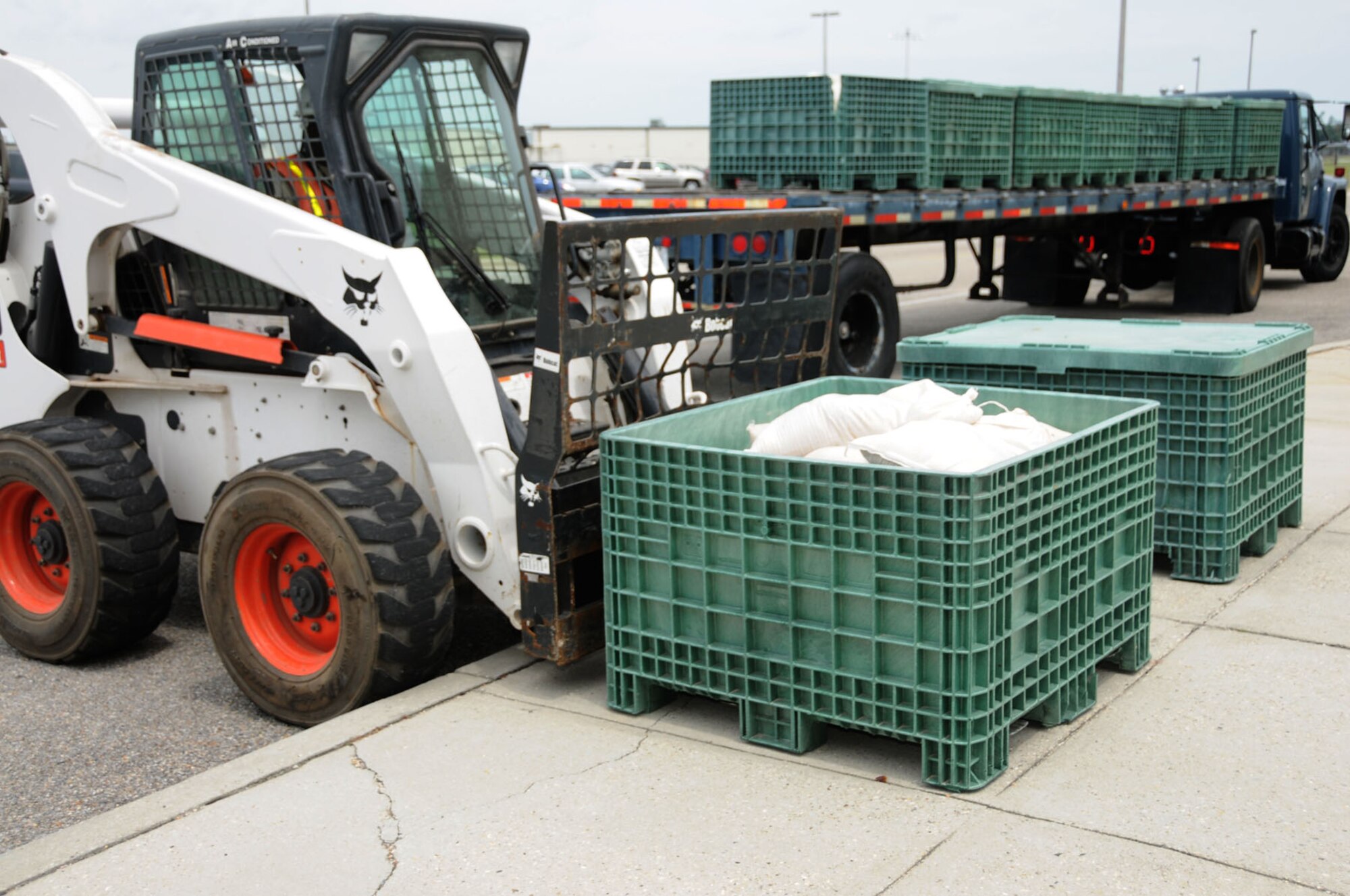 Bobcat operator Russell Johnson  from KIRA/CSC delivers sandbags to Wolfe Hall July 22.  (U.S. Air Force photo by Kemberly Groue)
