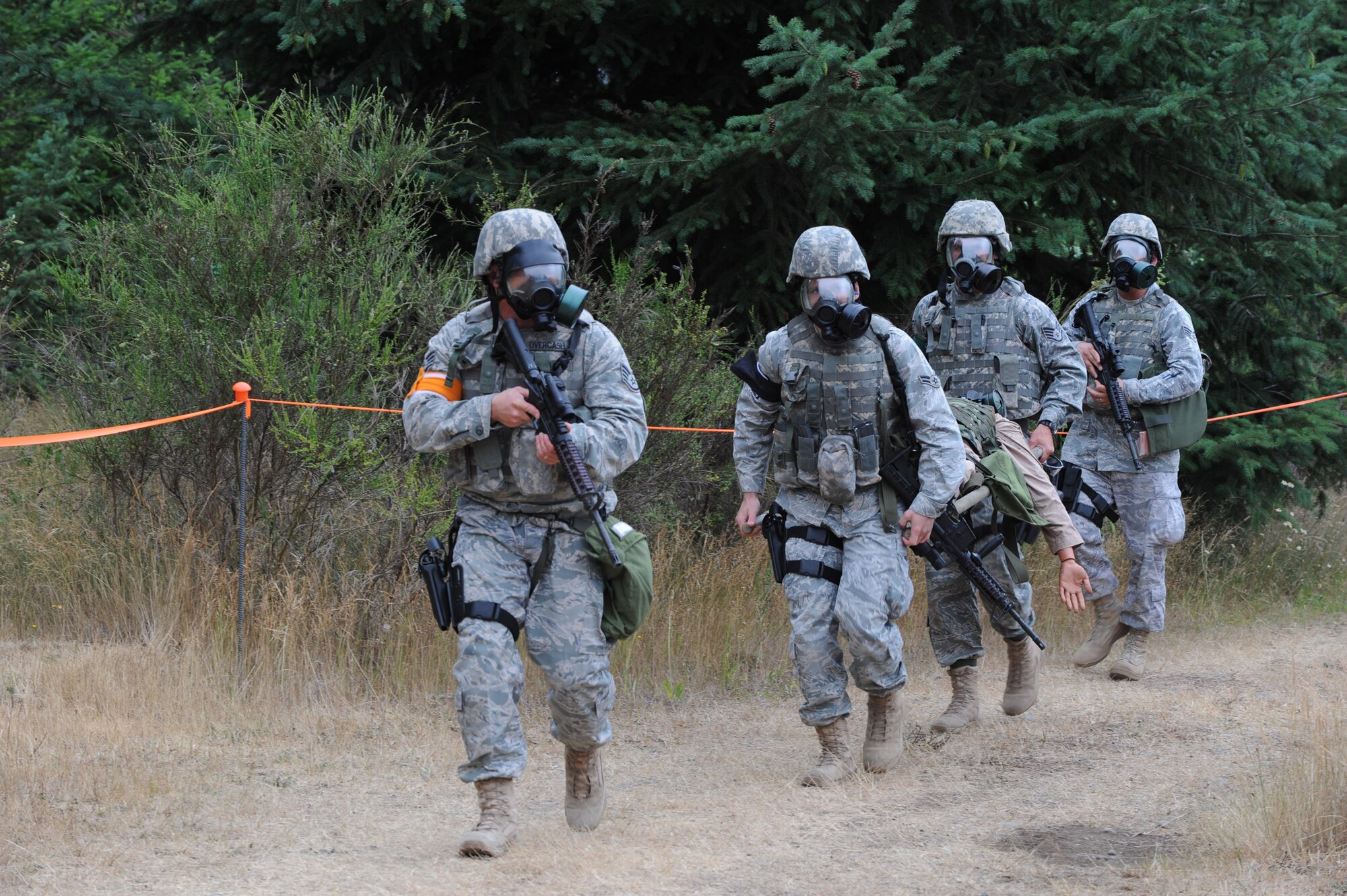 MCCHORD AIR FORCE BASE, Wash. -- Members of Team McConnell’s RODEO security forces team wear gas masks while carrying a simulated wounded victim during the RODEO combat weapons competition. The simulated wounded victim was a 165 pound mannequin wearing more than 40 pounds of field gear. (Photo by Tech. Sgt. Chyrece Campbell) 