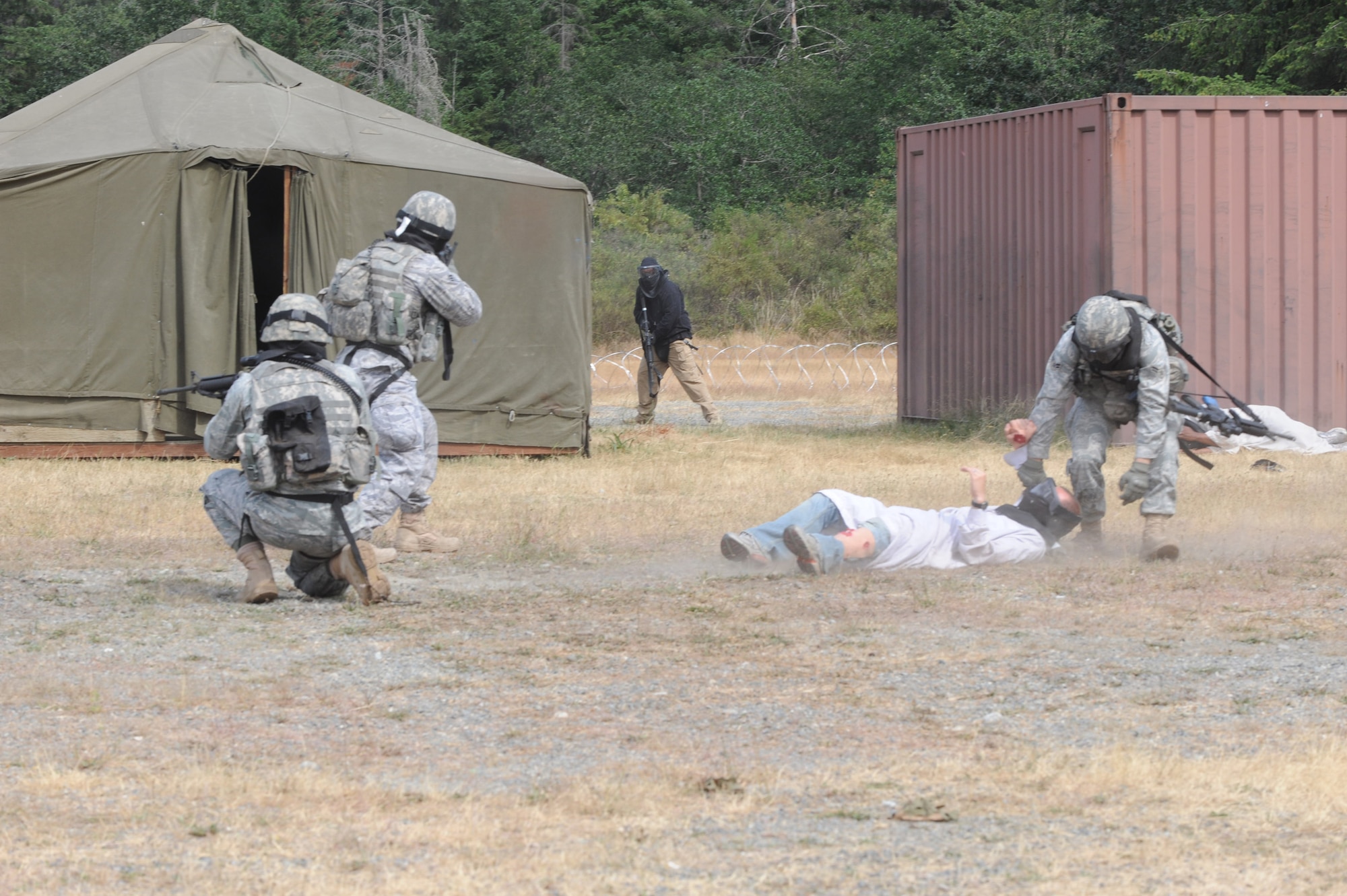 MCCHORD AIR FORCE BASE, Wash. -- Airman 1st Class Eric Hargarten, 22nd Security Forces Squadron, pulls an informant to safety while Team McConnell’s RODEO security forces team members provide cover while under enemy fire during the RODEO combat tactics competition, July 20. RODEO is the Air Mobility Command’s readiness competition.  RODEO competitions test the skills of aircrews, special tactics, security forces, aerial port operations, aeromedical evacuations and maintenance team members. (Photo by Tech. Sgt. Chyrece Campbell)  