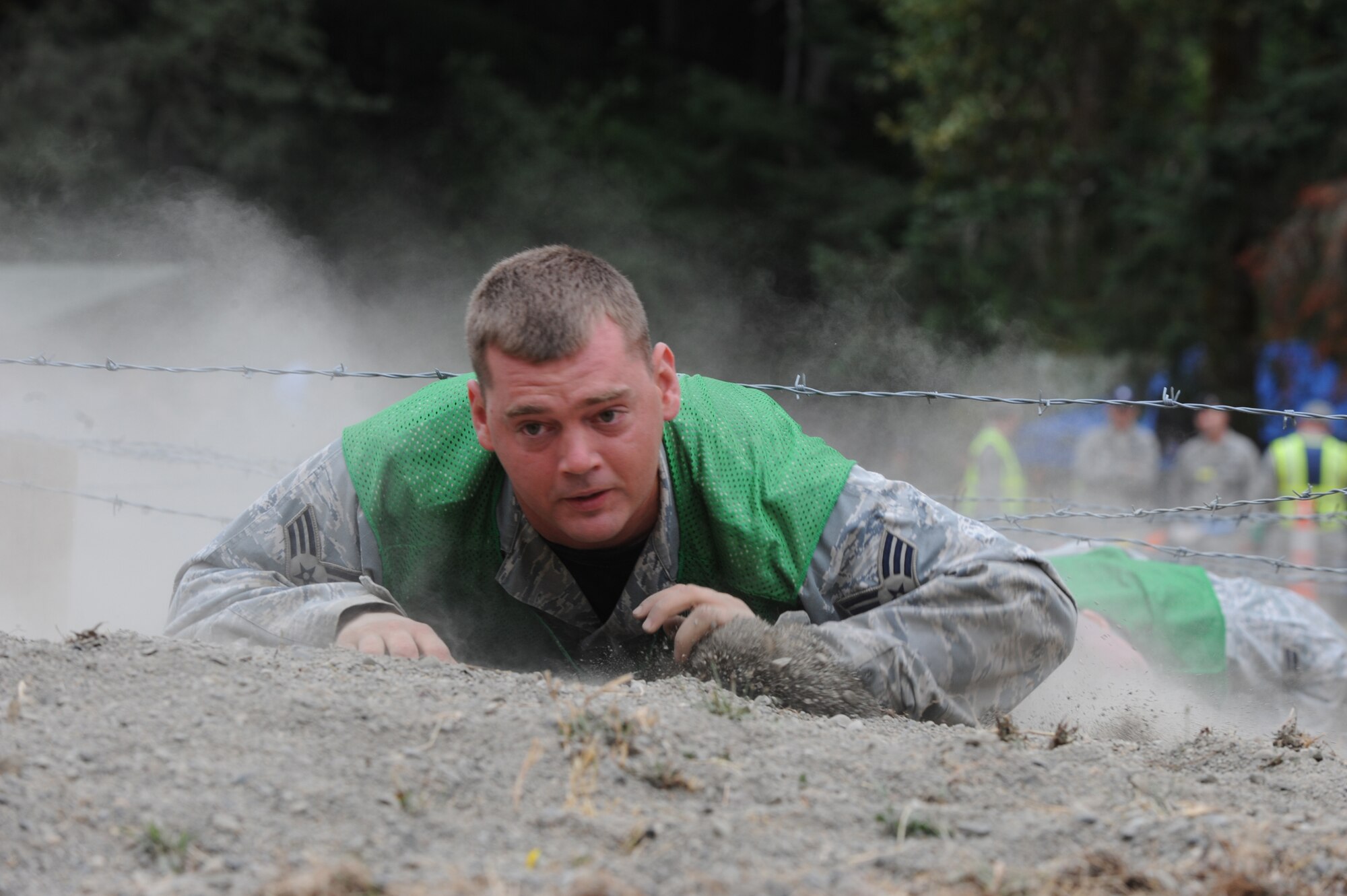 MCCHORD AIR FORCE BASE, Wash.-- Senior Airman Nathan Shelley, 931st Air Refueling Group, low crawls under barbed wire during the RODEO combat endurance competition  July 23 at McChord AFB, Wash. Airman Shelley started actively training with the RODEO security forces team in early July. (Photo by Tech. Sgt. Chyrece Campbell)  