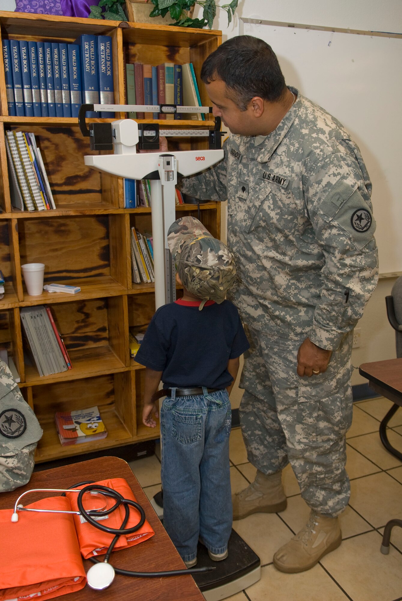 U.S. Army Spc. Eric Enriquez checks the weight of a young patient at the Medical Innovative Readiness Team Site (MIRTS) located at the LaSara Community Resource Center,  LaSara, Texas during Operation Lone Star.  Operation Lone Star is a Joint Civilian/Military Medical mission offering free Medical care to the region, 29 July 2009.(USAF Photo by Master Sgt. Michael Lachman) 