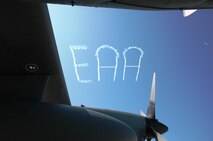 A skywrighter overhead marks the Experimental Aircraft Association as seen through the wing and fuselage of an Air Force Reserve C-130 July 29 at the 2009 Experimental Aircraft Association AirVenture air show in Oshkosh, Wis. the Air Force Reserve's 302nd Airlift Wing, participated in this year's air show by demonstrating the new MAFFS II capabilities on July 27 with a live air drop. The air show is known as the world's greatest aviation celebration and attracts hundreds of thousands of aviation enthusiasts from all over the world. The C-130, assigned to the 302nd AW at Peterson Air Force Base, Colo., is equipped with the new MAFFS II system and is on display at EAA AirVenture through July 29. (U.S. Air Force photo/Capt. Jeff Schoen)