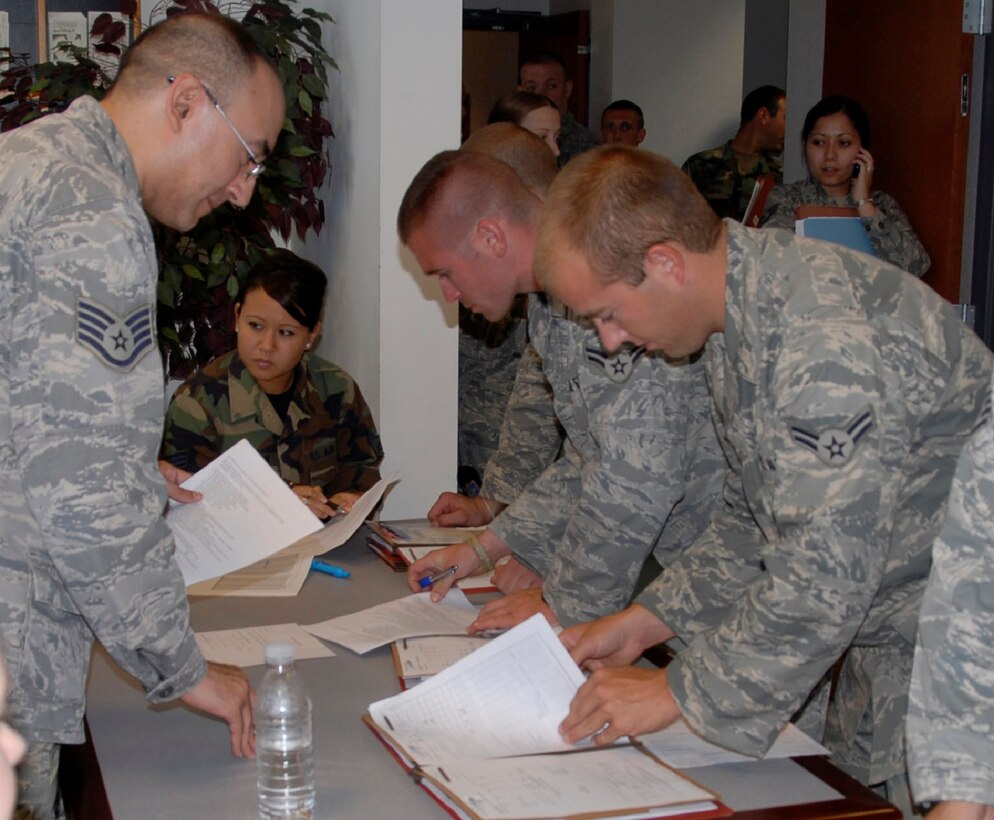 Airmen 1st Class Chad Beintker and Michael Raymond, both Security Forces apprentices with the 126th Security Forces Squadron, update their personal information while going through the personnel deployment processing line June 28.  
     More than 30 members of the 126 SFS have been mobilized in support of Operation Iraqi Freedom and will be serving in a forward deployed location for approximately a year.  Prior to deploying, personnel processed through the PDF line for assistance with personal needs such as, finance, family support, legal, chaplain assistance, and updating personnel records.  
     In the PDF line, personnel are given the opportunity to update their living will, be given a detailed print out of their estimated financial earnings while mobilized and deployed, free calling cards, and religious materials.  