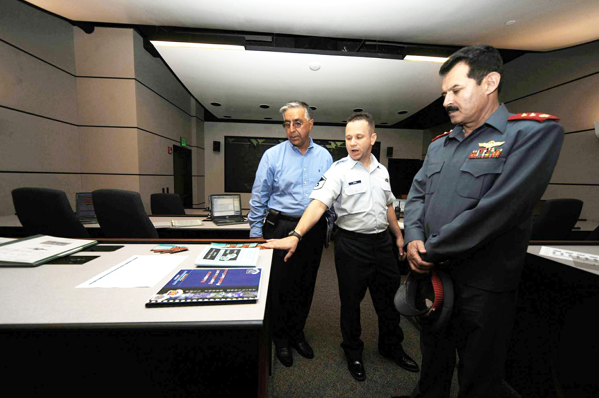 Master Sgt. Richard Woods explains the maintenance simulator and shows guides and pamphlets to Afghan Maj. Gen. Mohammad Dawran July 13 at the Air Force Expeditionary Center on Joint Base McGuire-Dix-Lakehurst, N.J. General Dawran, commander of the Afghanistan National Army Air Corps, visited the installation to learn more about the Air Education and Training Command's Air Adviser Course housed at the Expeditionary Center on Fort Dix. Sergeant Woods is the director of the Senior Leaders Maintenance Course. (U.S. Air Force photo/Staff Sgt. Nathan G. Bevier) 