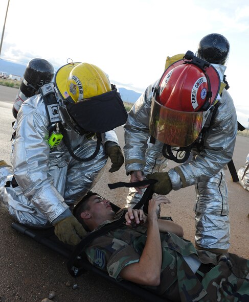 HOLLOMAN AIR FORCE BASE, N.M. -- Holloman Fire Emergency Services personnel rescue victims after a simulated aircraft crash during the Major Accident Response Exercise here July 23. MARE exercises are a yearly requirement for all Air Combat Command bases to maintain readiness of both first-responders and command and control and to exercise emergency response functions. (U.S. Air Force photo by Airman 1st Class Sondra M. Escutia)