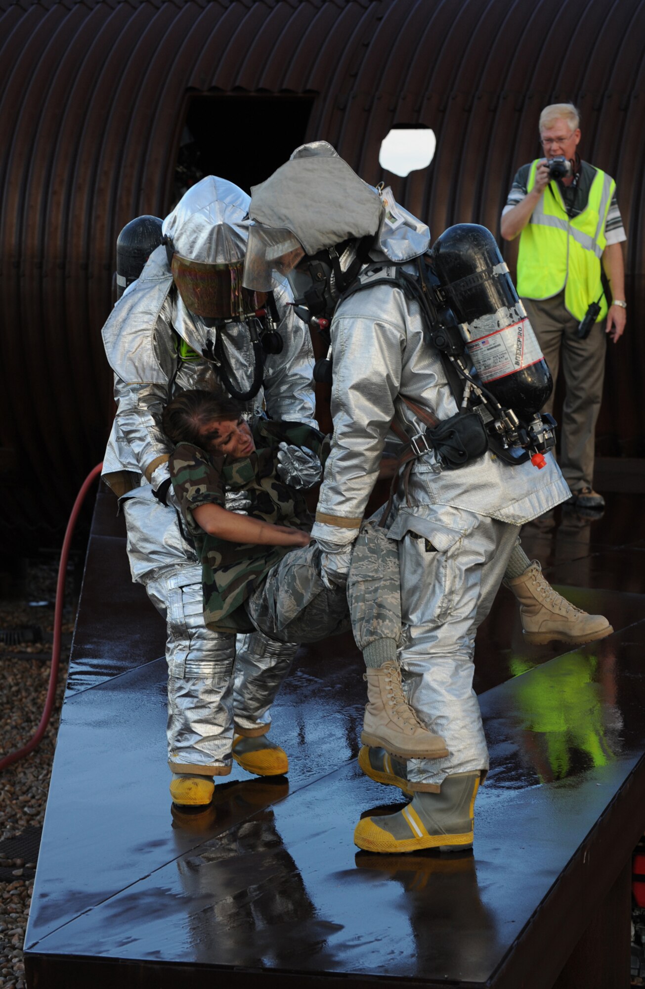 HOLLOMAN AIR FORCE BASE, N.M. -- Holloman Fire Emergency Services personnel perform a two-man carry of a role-player of a simulated aircraft crash during the Major Accident Response Exercise here July 23. Role-players were used to simulate an emergency situation which required first-responders to act quickly. The Fire Emergency Services personnel manually removed all seven victims and transported them to a safe distance from the crash. (U.S. Air Force photo by Airman 1st Class Sondra M. Escutia)